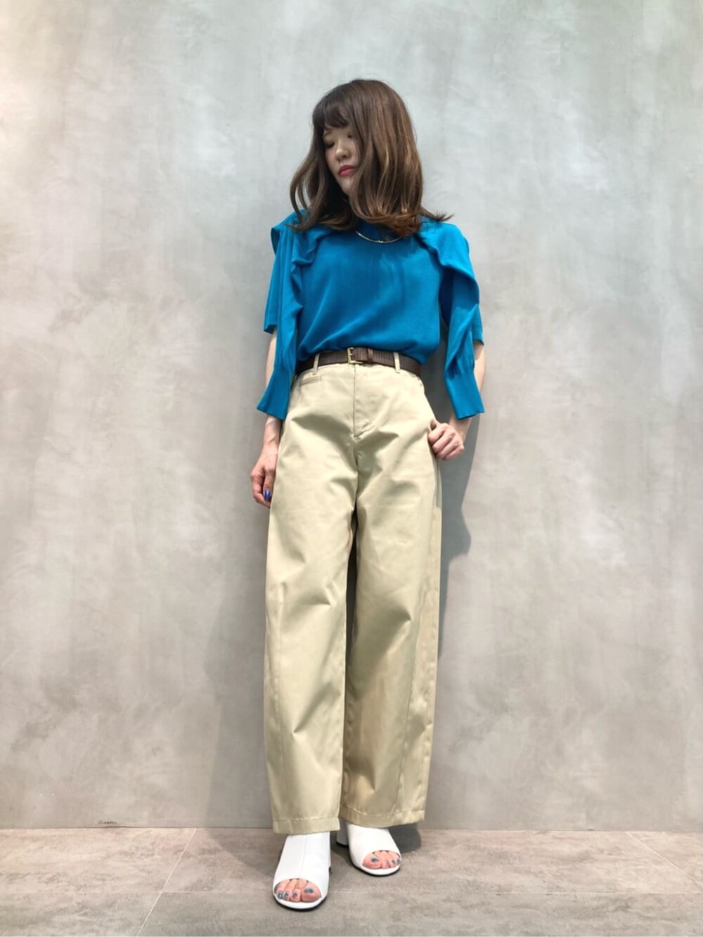 ベージュ系のチノパンツ、ホワイト系のサンダル、グリーン系のニット/セーターを着用したレディースの夏コーディネートの2枚目の写真