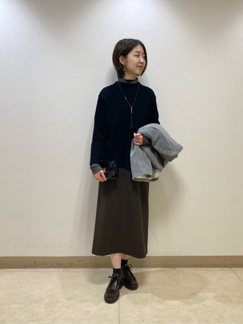 グレー系のその他アウター、ブラック系のスカートを着用したレディースの冬コーディネートの4枚目の写真