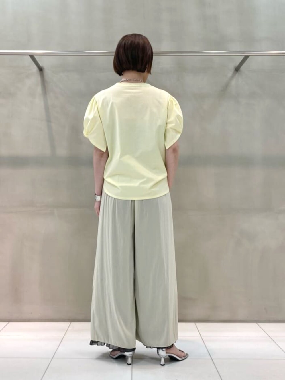 グレー系のシャツ/ブラウス、グレー系のその他パンツ、イエロー系のトートバッグを着用したレディースの春コーディネートの9枚目の写真