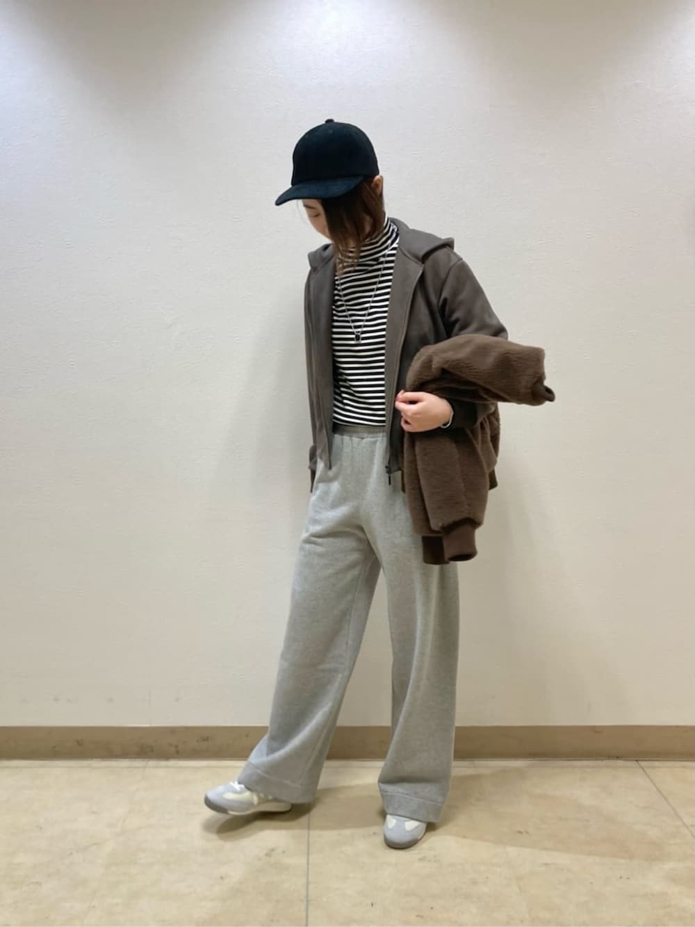 ブラウン系のブルゾン、グレー系のその他パンツ、ブラック系のキャップを着用したレディースの冬コーディネートの5枚目の写真