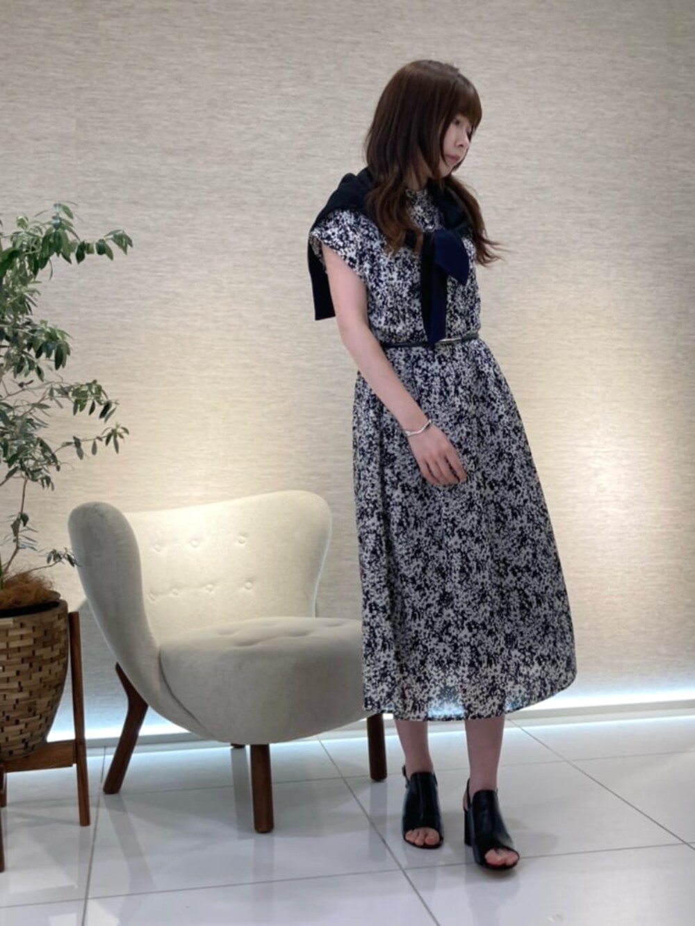 ブラック系のサンダル、ブラック系のニット/セーター、ブルー系のワンピースを着用したレディースの夏コーディネートの3枚目の写真