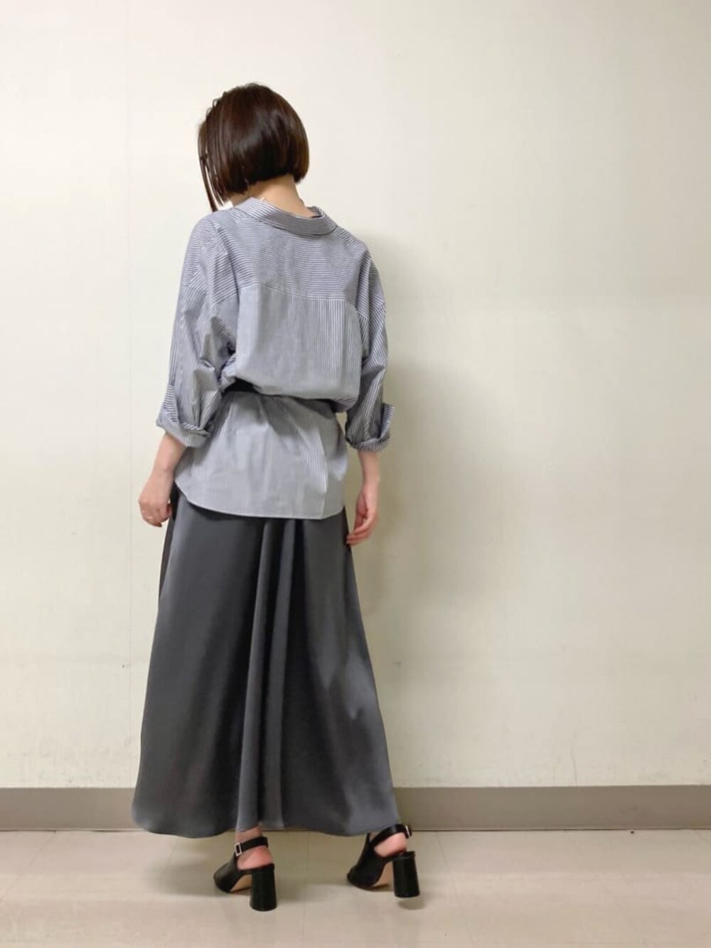 グレー系のワンピース、ブラック系のサンダル、ブルー系のシャツ/ブラウスを着用したレディースの春コーディネートの3枚目の写真