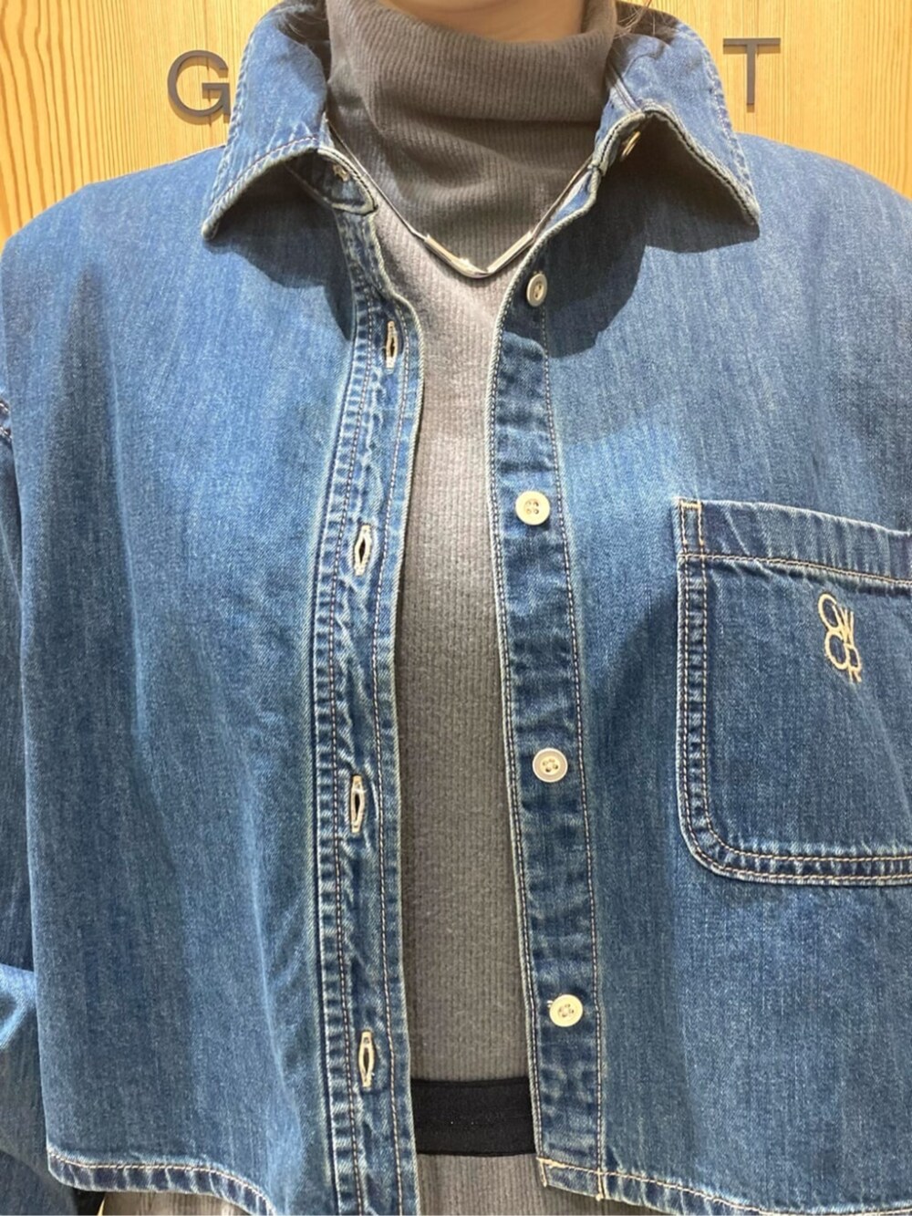 ブルー系のシャツ/ブラウス、ブルー系のダウンジャケット/コート、グレー系のスカートを着用したレディースの冬コーディネートの7枚目の写真