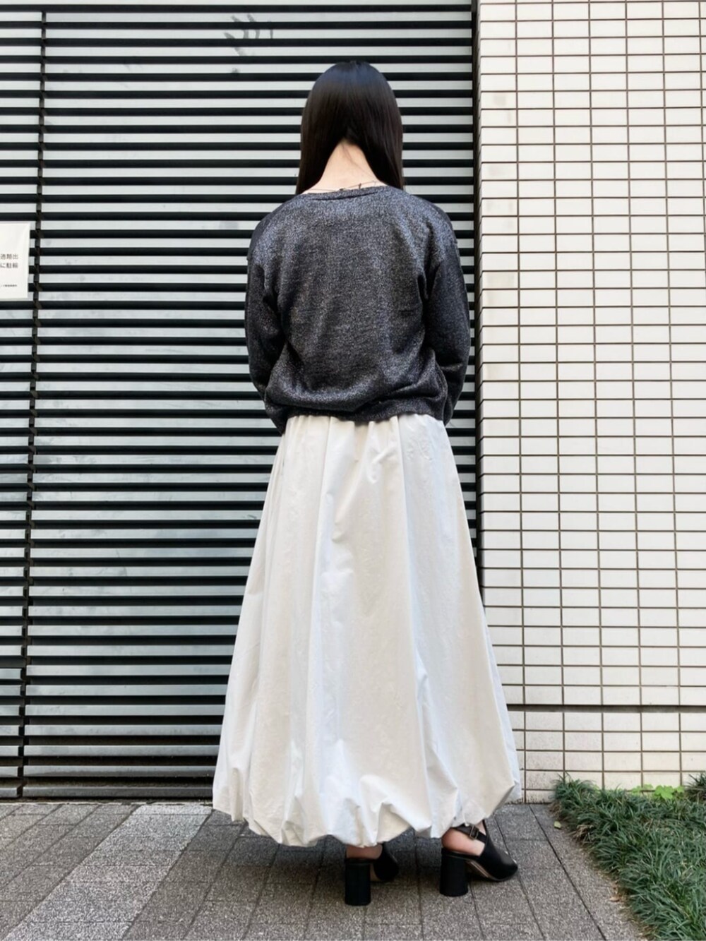 ホワイト系のショルダーバッグ、ベージュ系のスカート、ブラック系のサンダルを着用したレディースの夏コーディネートの4枚目の写真