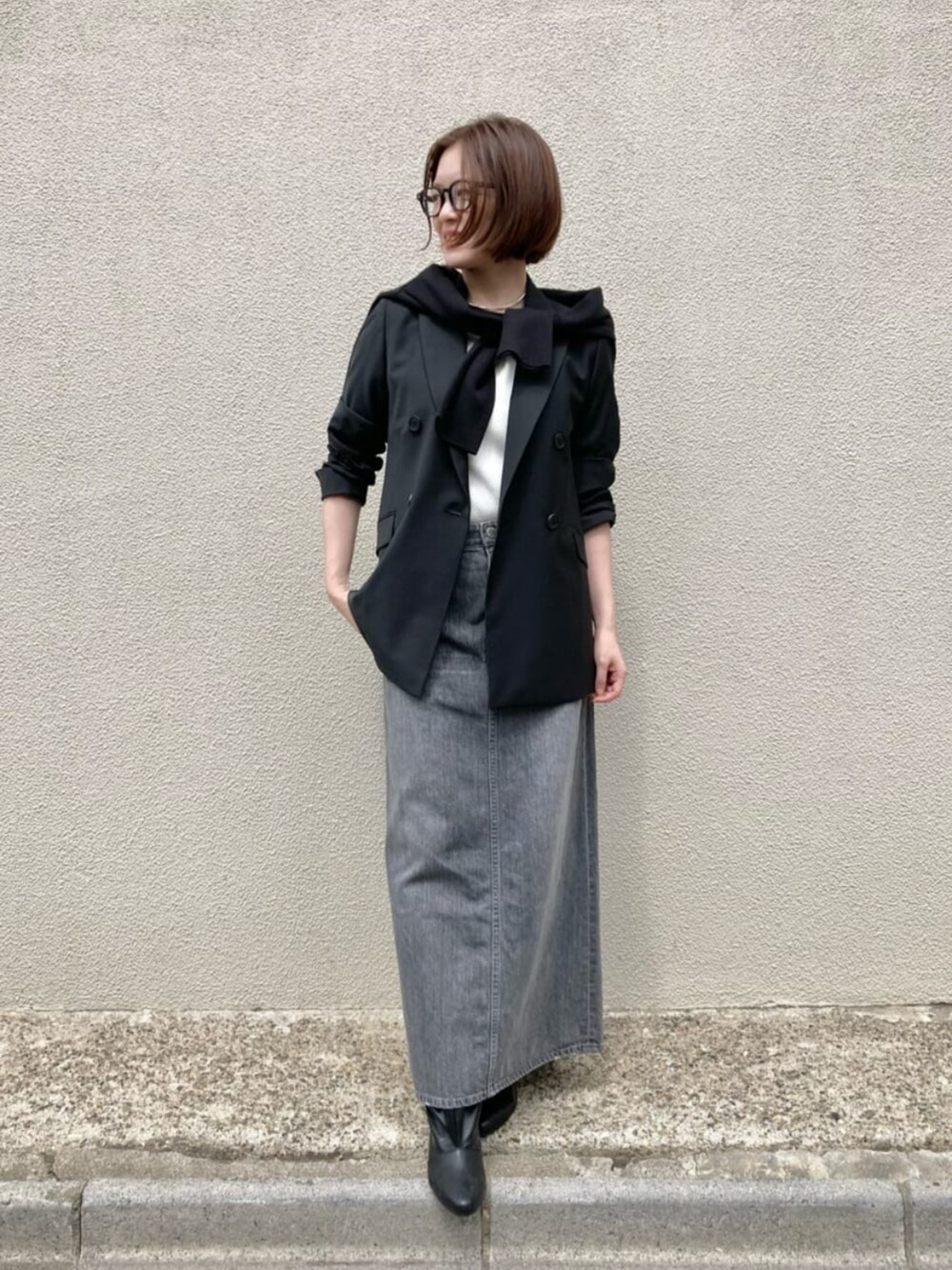 ホワイト系のニット/セーター、ブラック系のカーディガン/ボレロ、グレー系のスカートを着用したレディースの秋コーディネートの2枚目の写真