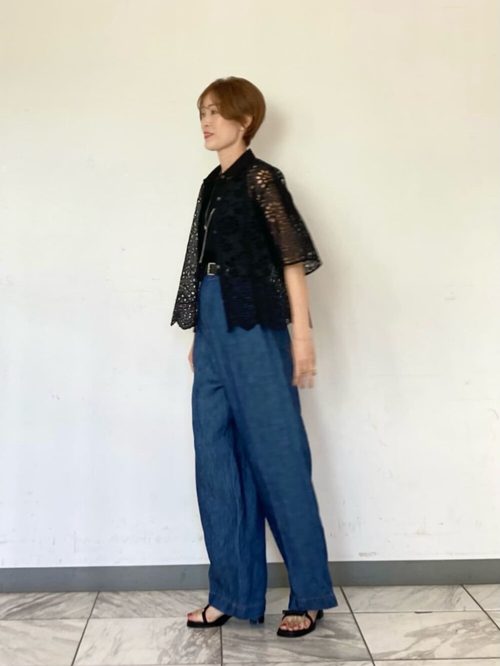 ブラック系のシャツ/ブラウス、ブラック系のサンダル、ブルー系のその他パンツを着用したレディースの春コーディネートの3枚目の写真