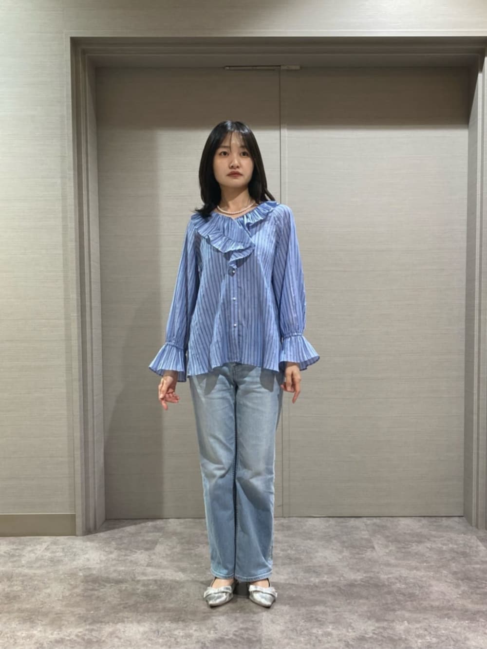 ホワイト系のショルダーバッグ、ブルー系のシャツ/ブラウス、ブラック系のベストを着用したレディースの春コーディネートの3枚目の写真