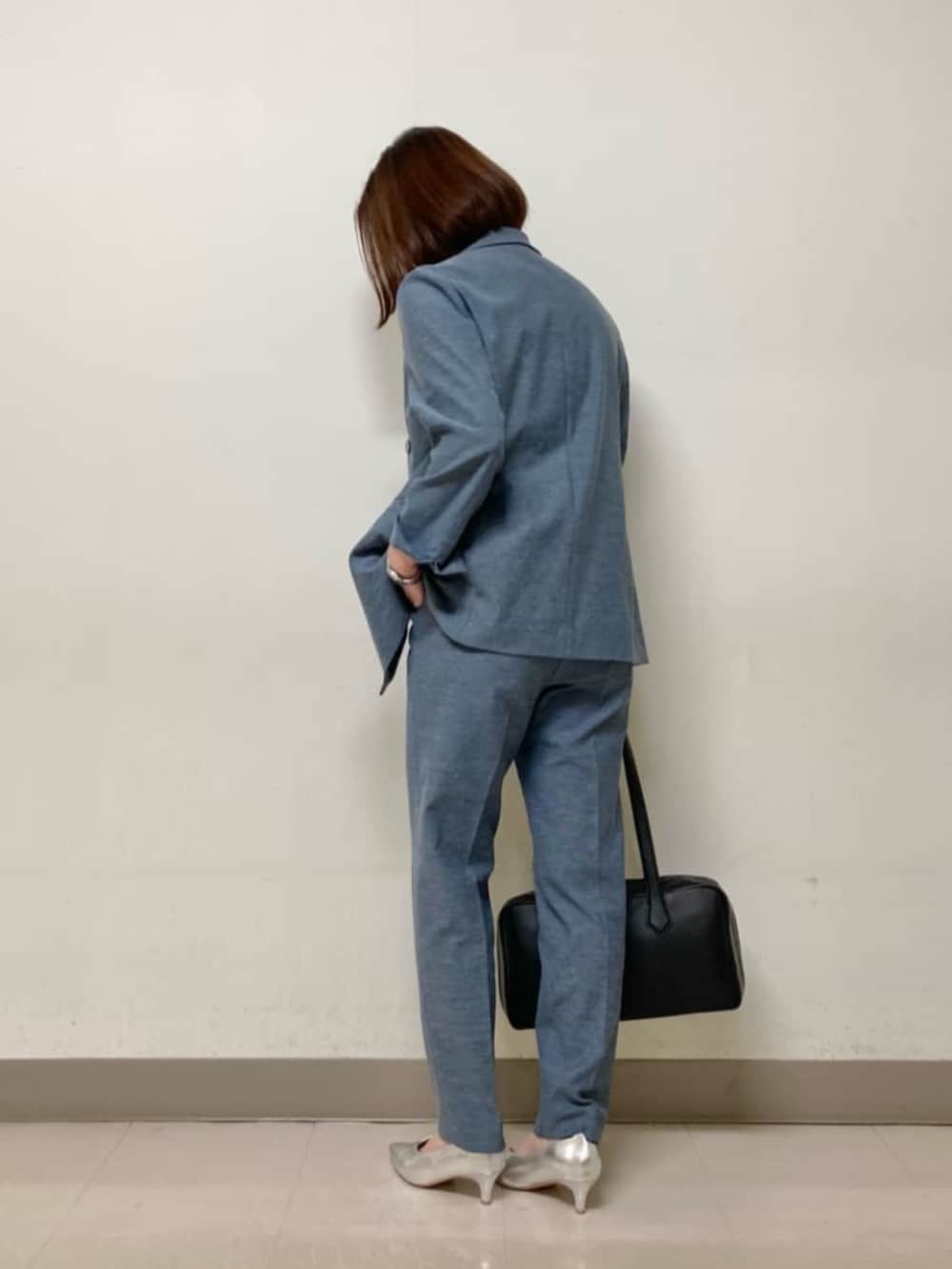 ブルー系のテーラードジャケット、ブルー系のその他パンツ、ブラック系のボストンバッグを着用したレディースの春コーディネートの4枚目の写真