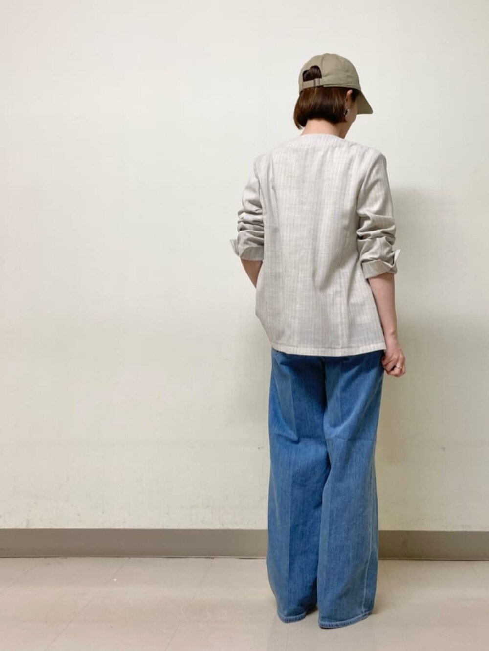 ブルー系のデニムパンツ、ホワイト系のTシャツ/カットソー、ホワイト系のノーカラージャケットを着用したレディースの夏コーディネートの3枚目の写真