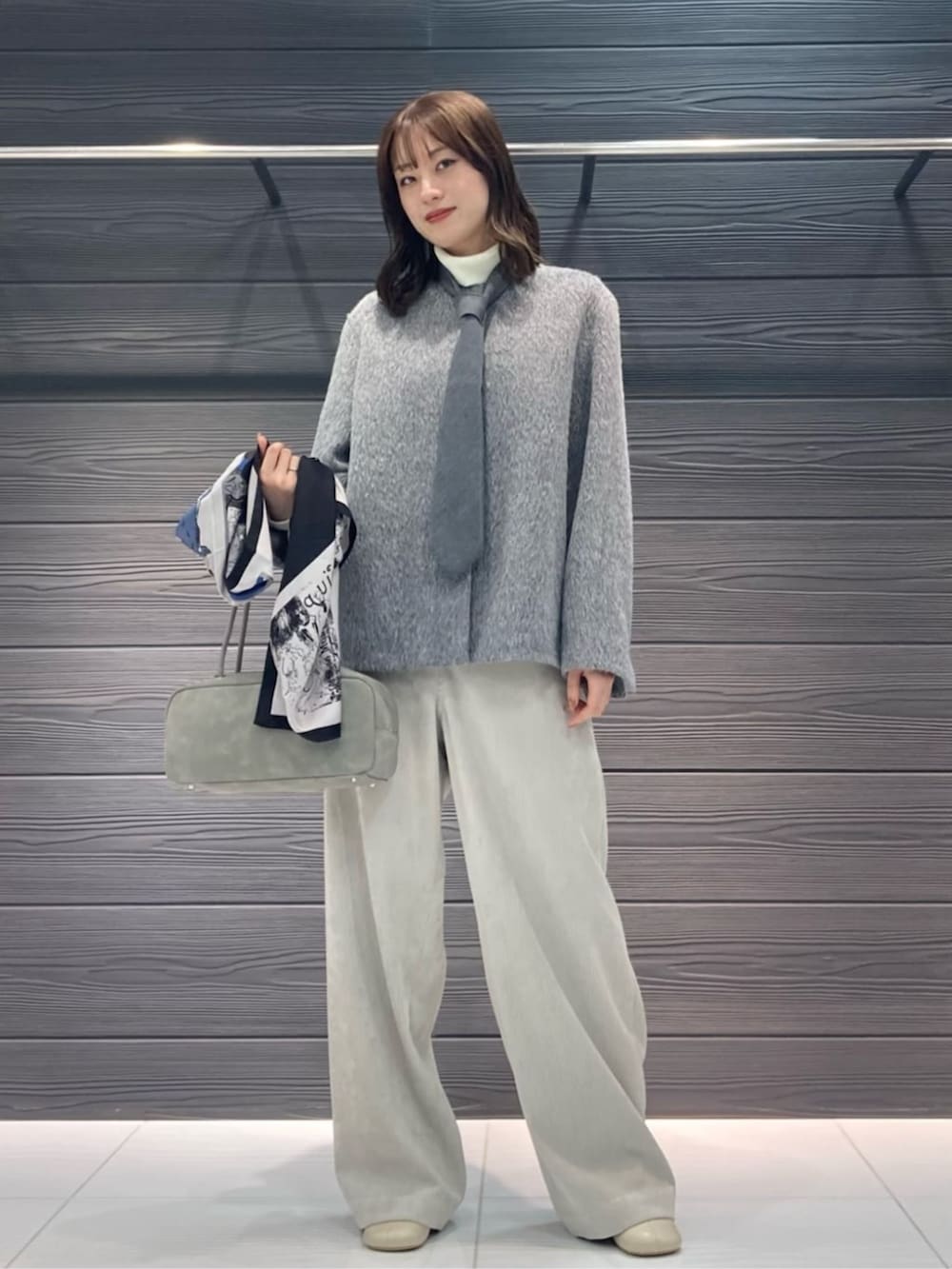 ベージュ系のその他パンツ、グレー系のその他アウター、ブラック系のストール/ショールを着用したレディースの冬コーディネートの2枚目の写真