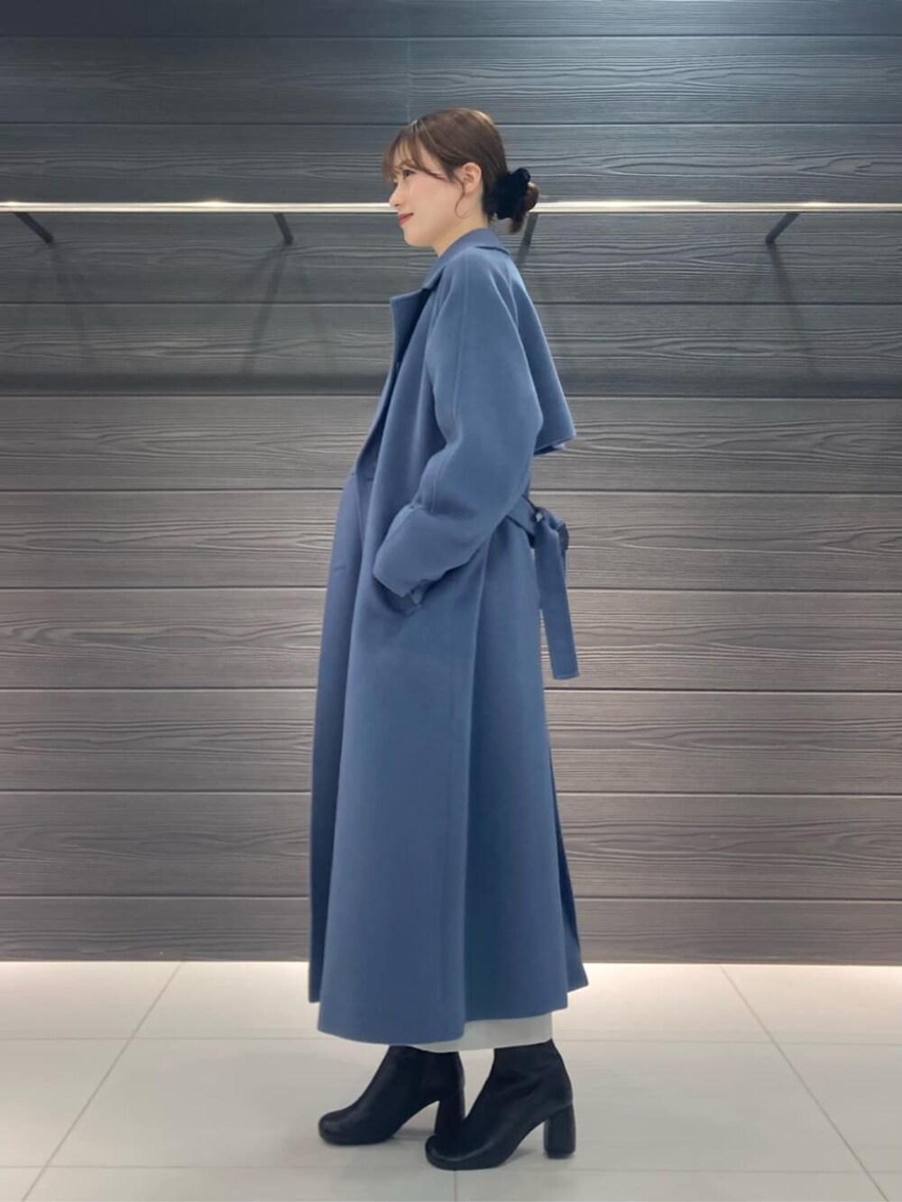 ブルー系のトレンチコート、グレー系のスカート、グレー系のニット/セーターを着用したレディースの冬コーディネートの4枚目の写真