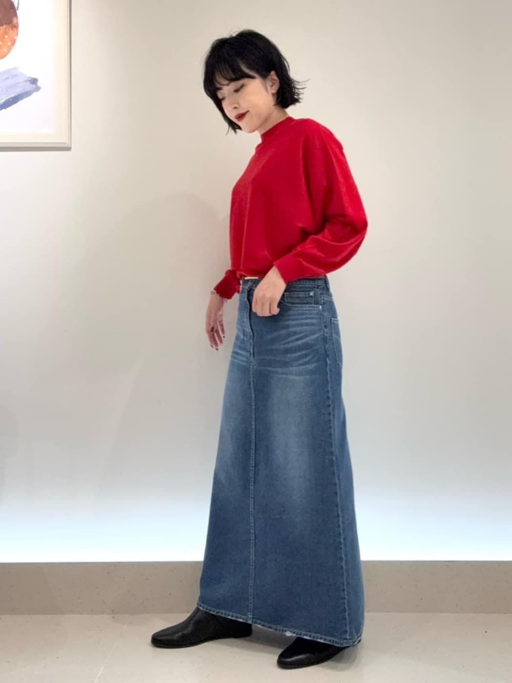 ブルー系のスカート、レッド系のアンサンブルを着用したレディースの秋コーディネートの2枚目の写真