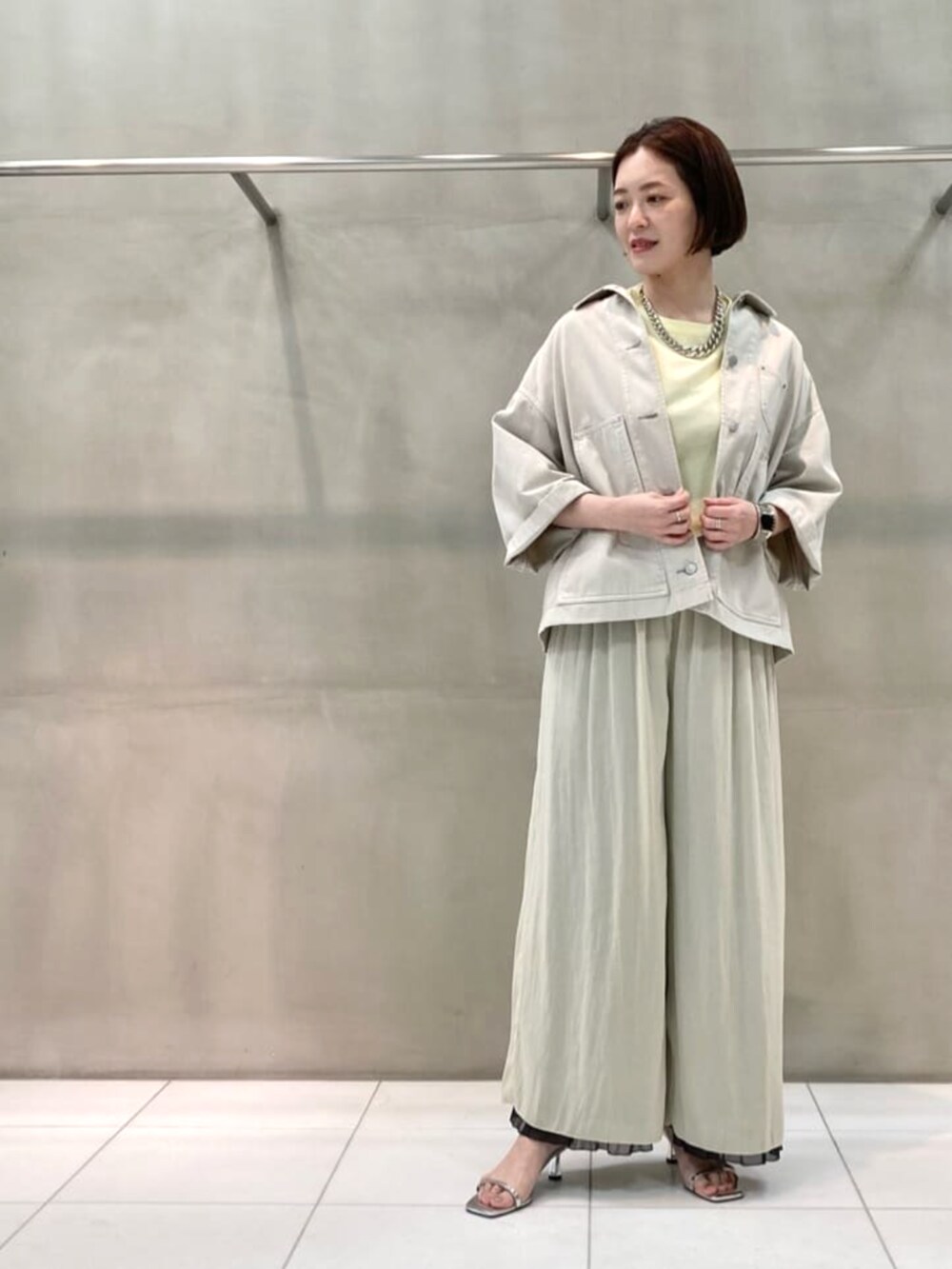 グレー系のシャツ/ブラウス、グレー系のその他パンツ、イエロー系のトートバッグを着用したレディースの春コーディネートの5枚目の写真