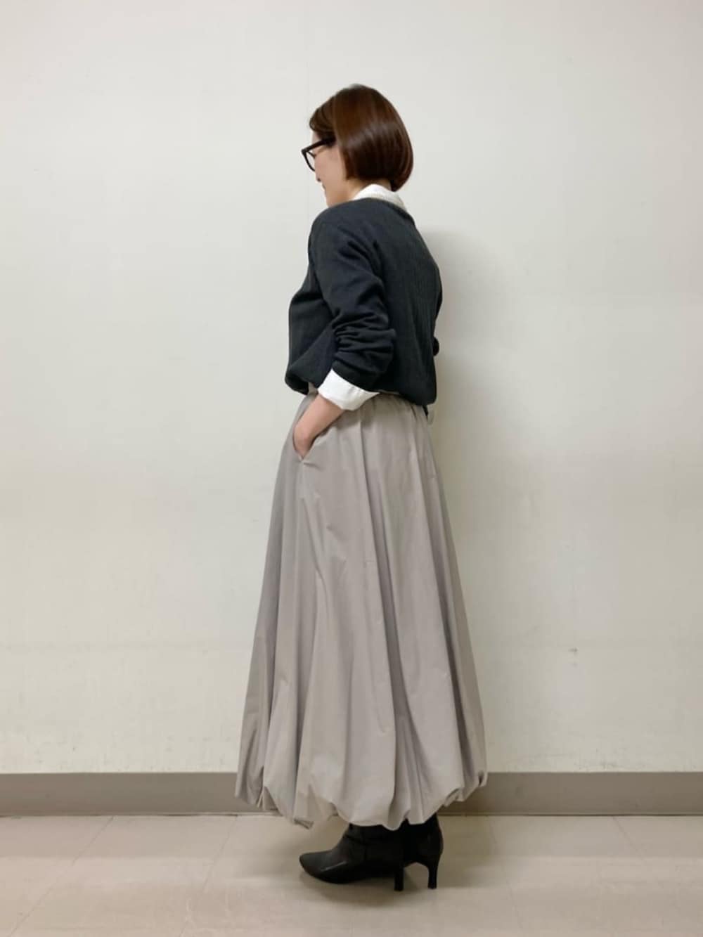 ベージュ系のスカート、グレー系のニット/セーター、ホワイト系のシャツ/ブラウスを着用したレディースの冬コーディネートの6枚目の写真