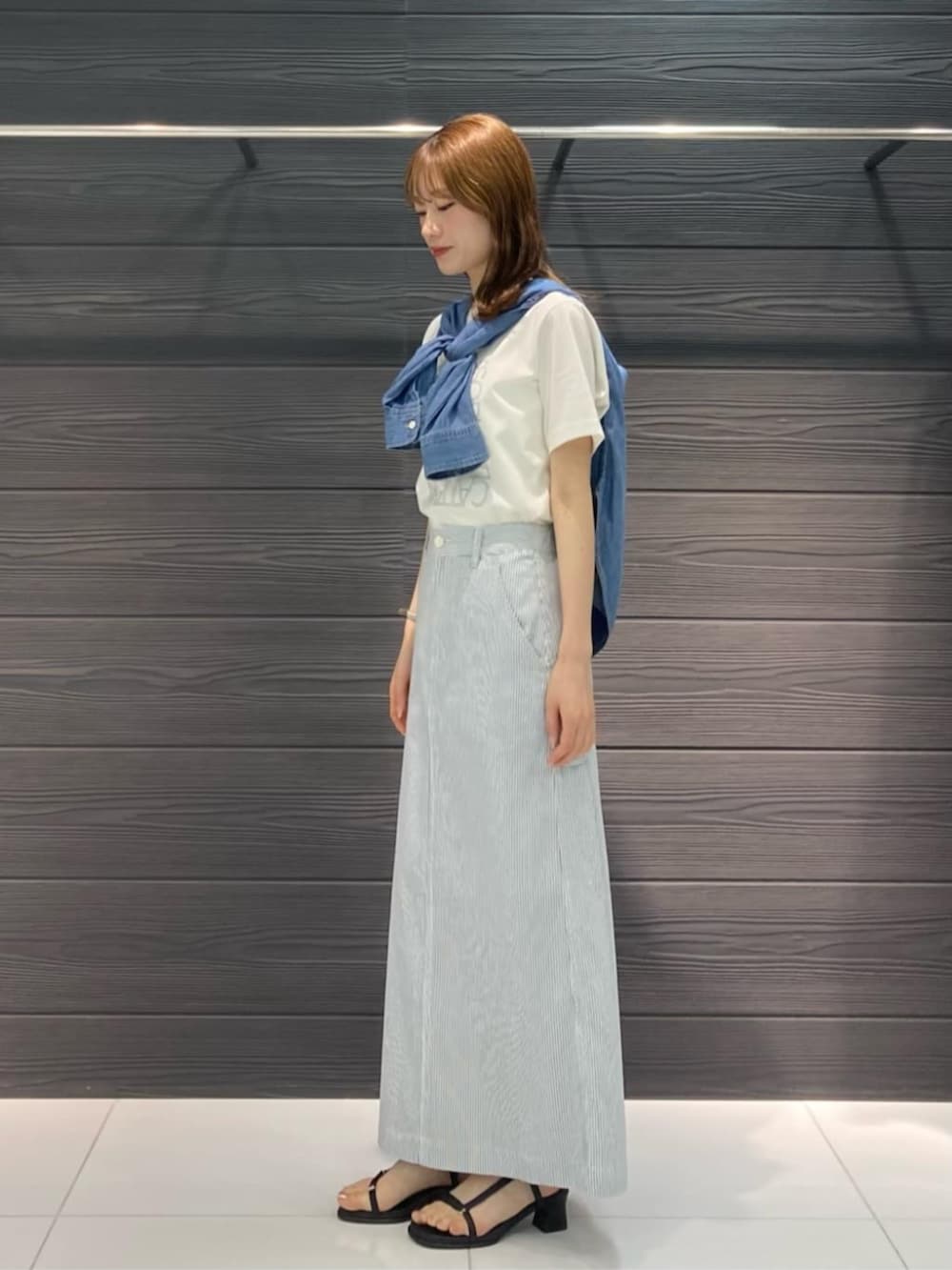 ホワイト系のTシャツ/カットソー、ブラック系のサンダル、ホワイト系のスカートを着用したレディースの春コーディネートの2枚目の写真