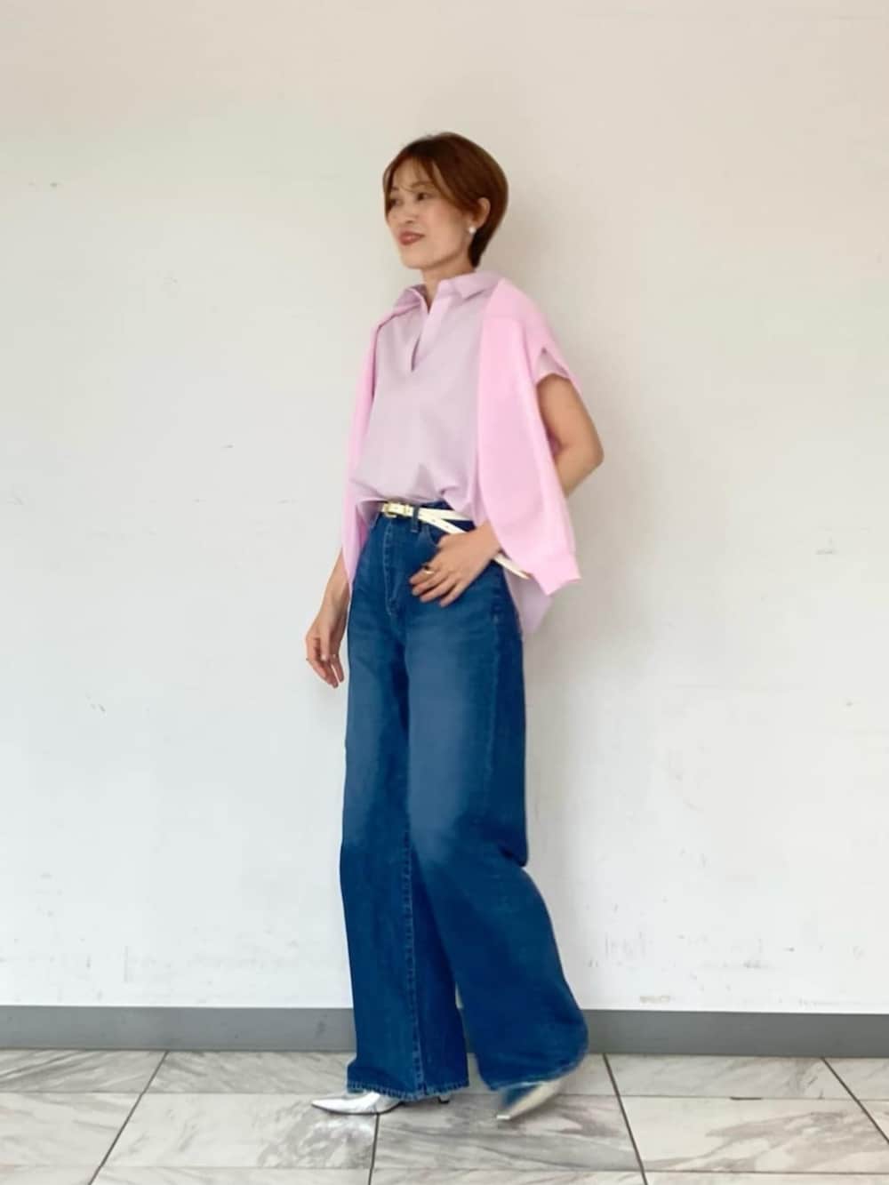 シルバー系のパンプス、ブルー系のデニムパンツ、ピンク系のシャツ/ブラウスを着用したレディースの夏コーディネートの3枚目の写真