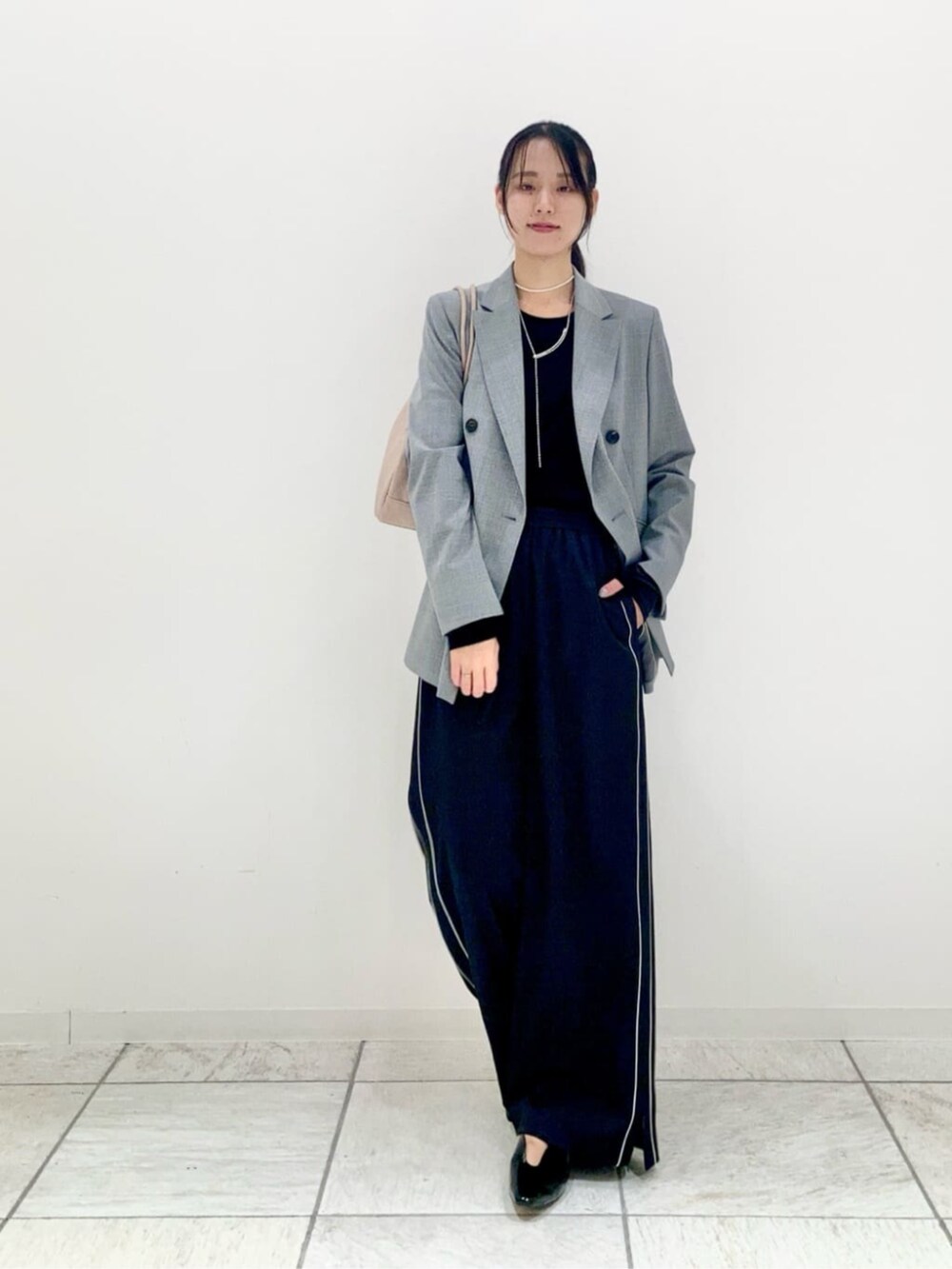 グレー系のスーツジャケット、ブラック系のその他パンツ、ブラック系のTシャツ/カットソーを着用したレディースの秋コーディネートの3枚目の写真
