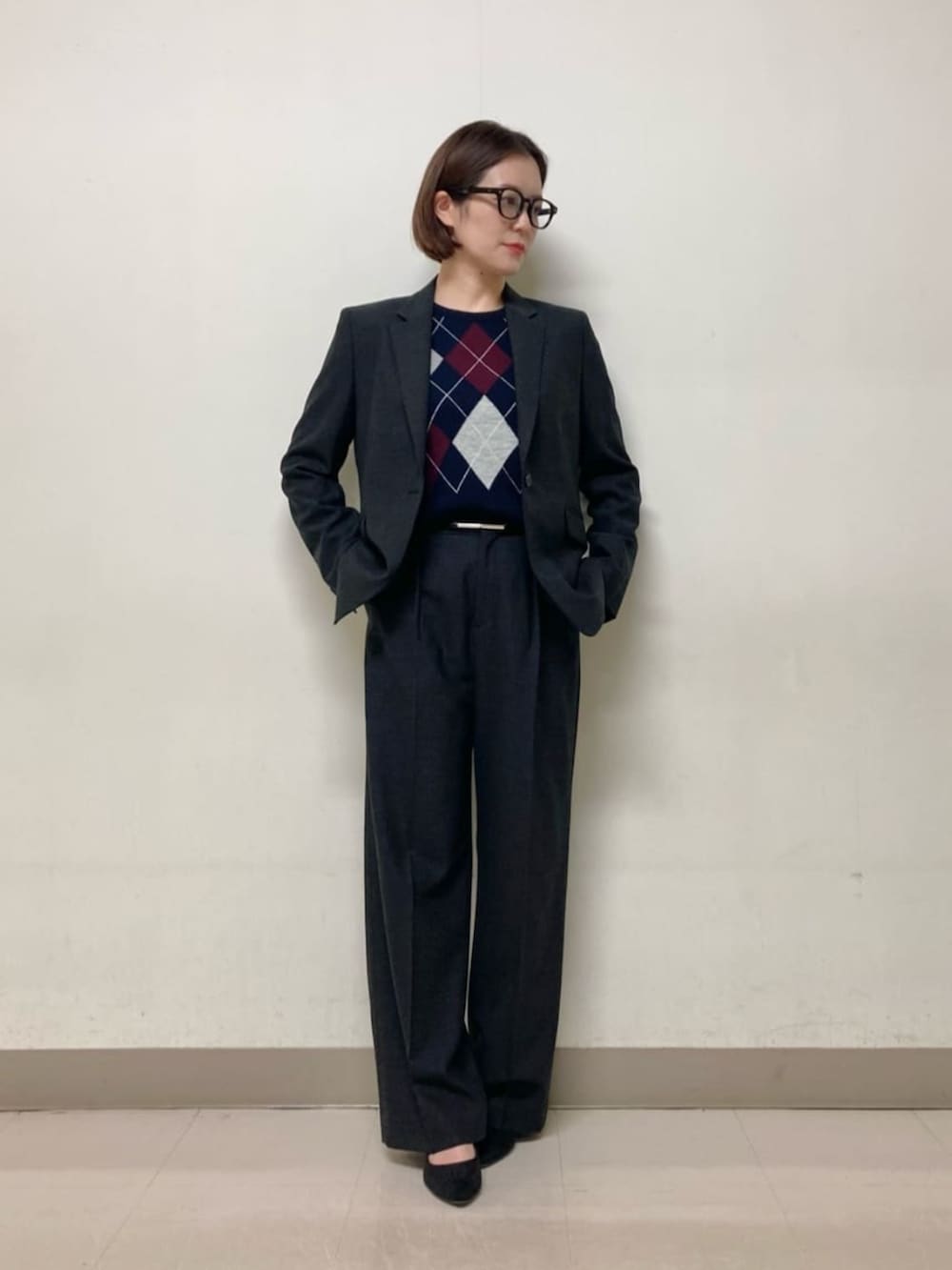 グレー系のスーツパンツ、グレー系のスーツジャケット、ブルー系のニット/セーターを着用したレディースの冬コーディネートの3枚目の写真