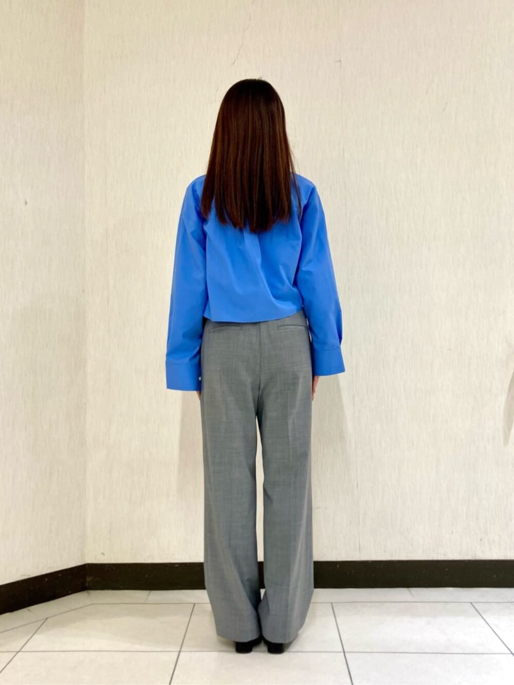 ブルー系のシャツ/ブラウス、ホワイト系のTシャツ/カットソー、グレー系のスーツパンツを着用したレディースの春コーディネートの4枚目の写真