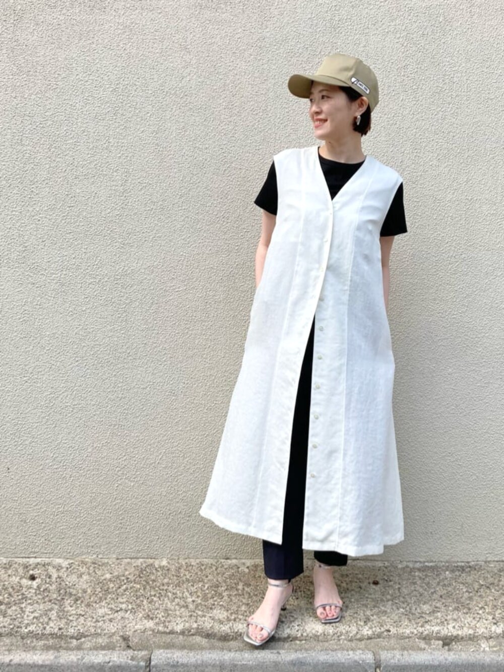 ホワイト系のトップス、ブラック系のTシャツ/カットソー、ブラック系のパンツを着用したレディースの春コーディネートの2枚目の写真