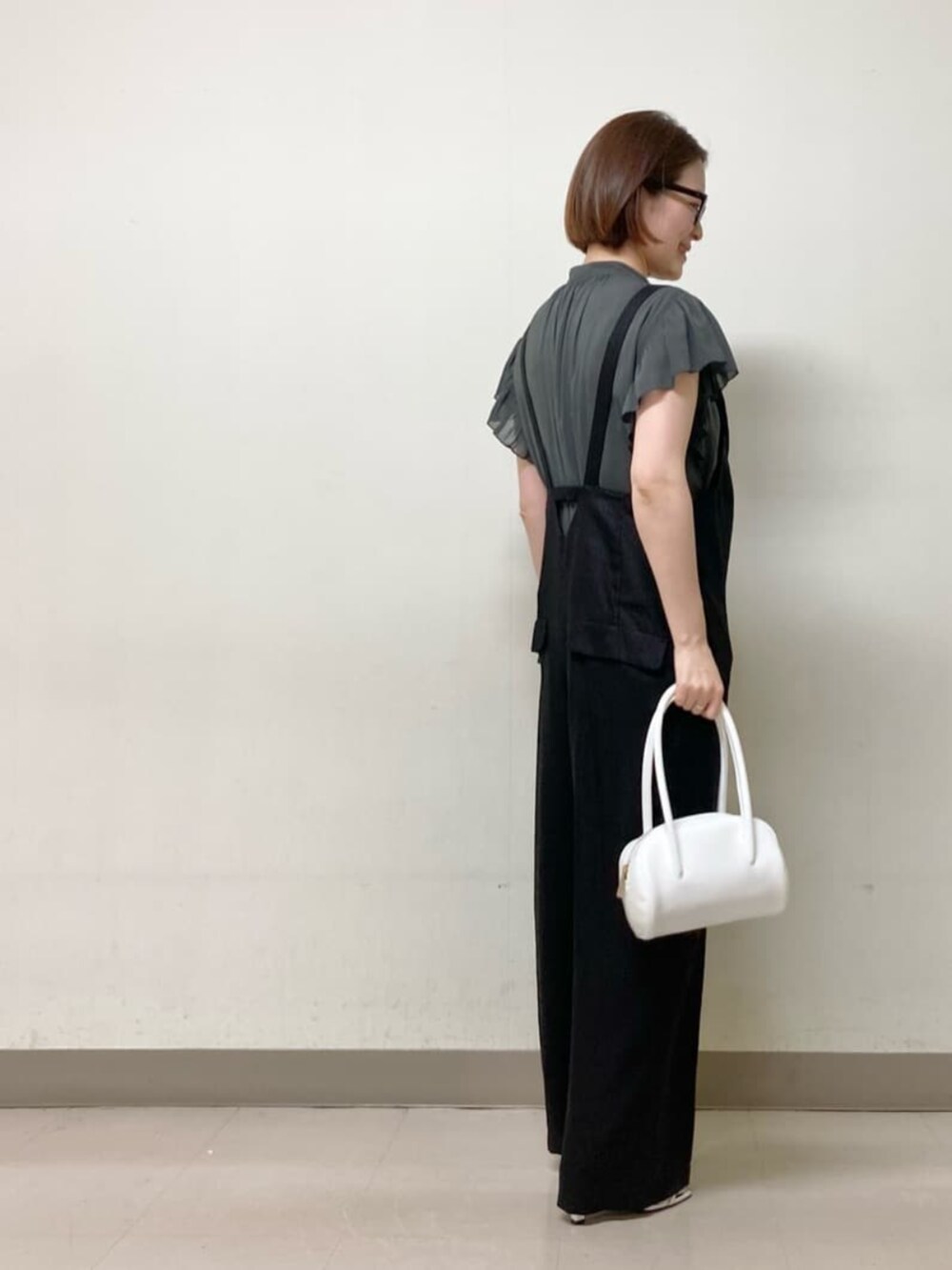グレー系のシャツ/ブラウス、ブラック系のオールインワン・サロペット、ホワイト系のバッグを着用したレディースの夏コーディネートの3枚目の写真
