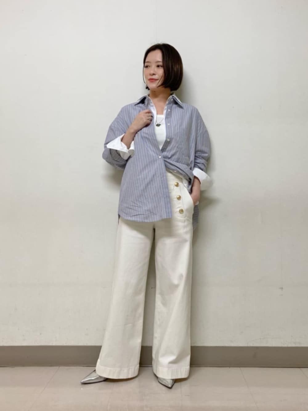 ブルー系のシャツ/ブラウス、ホワイト系のシャツ/ブラウス、ブルー系のデニムパンツを着用したレディースの春コーディネートの4枚目の写真