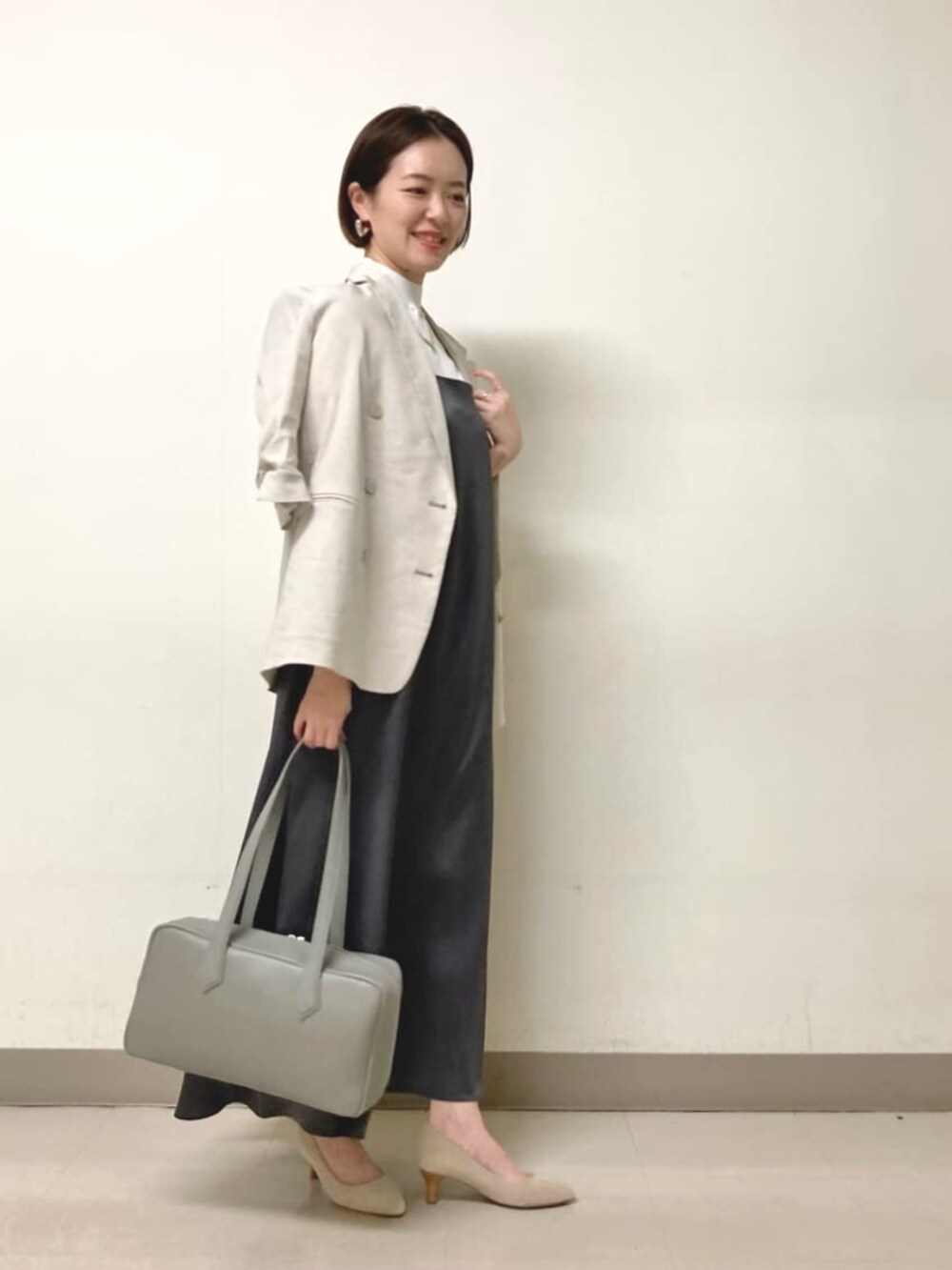 ホワイト系のニット/セーター、グレー系のテーラードジャケット、グレー系のワンピースを着用したレディースの春コーディネートの4枚目の写真