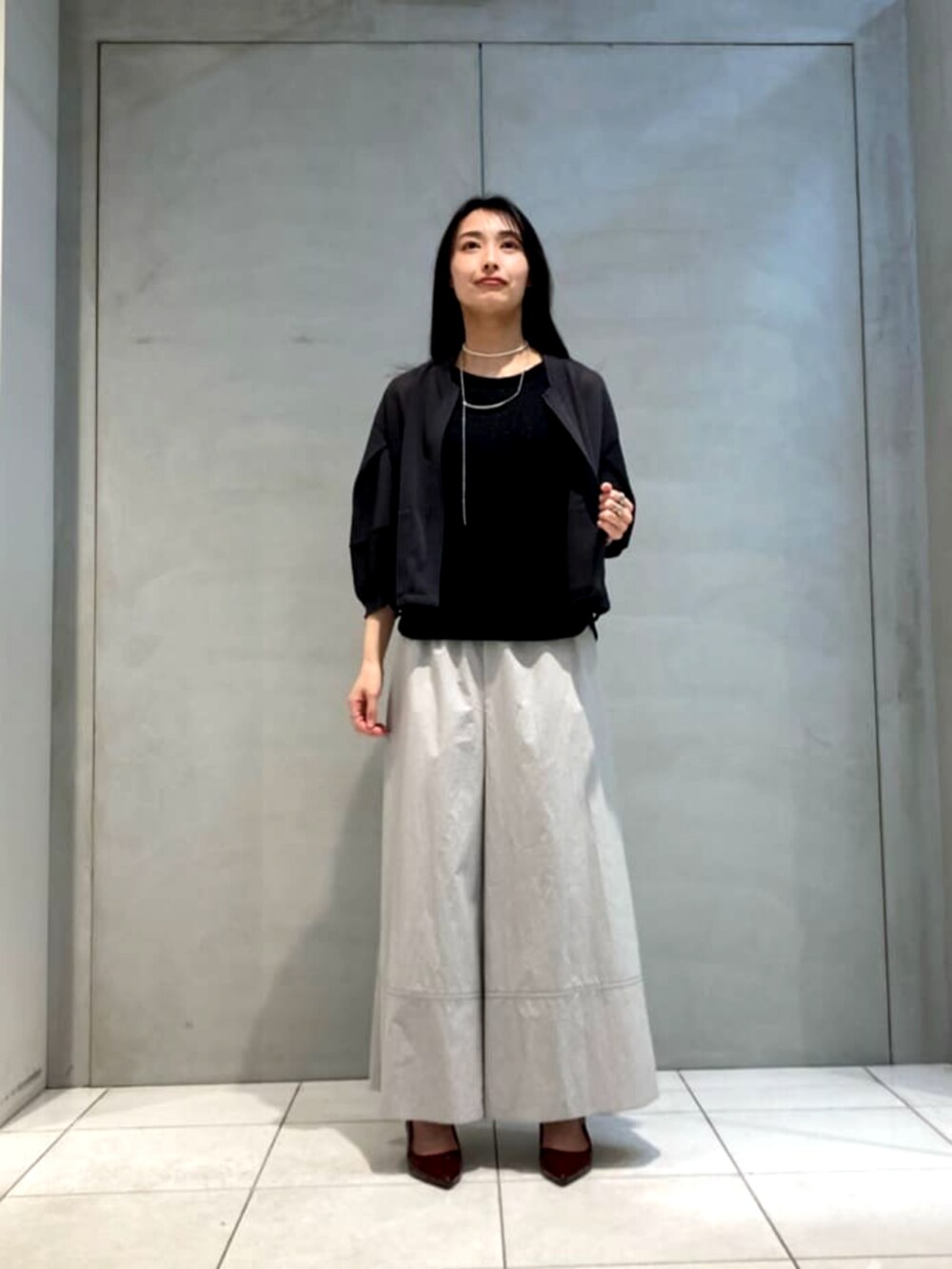 グレー系のその他パンツ、グレー系のブルゾン、ホワイト系のネックレスを着用したレディースの夏コーディネートの3枚目の写真