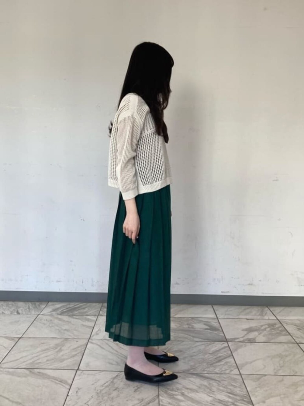 グリーン系のスカート、ブラウン系のストール/ショールを着用したレディースの春コーディネートの2枚目の写真