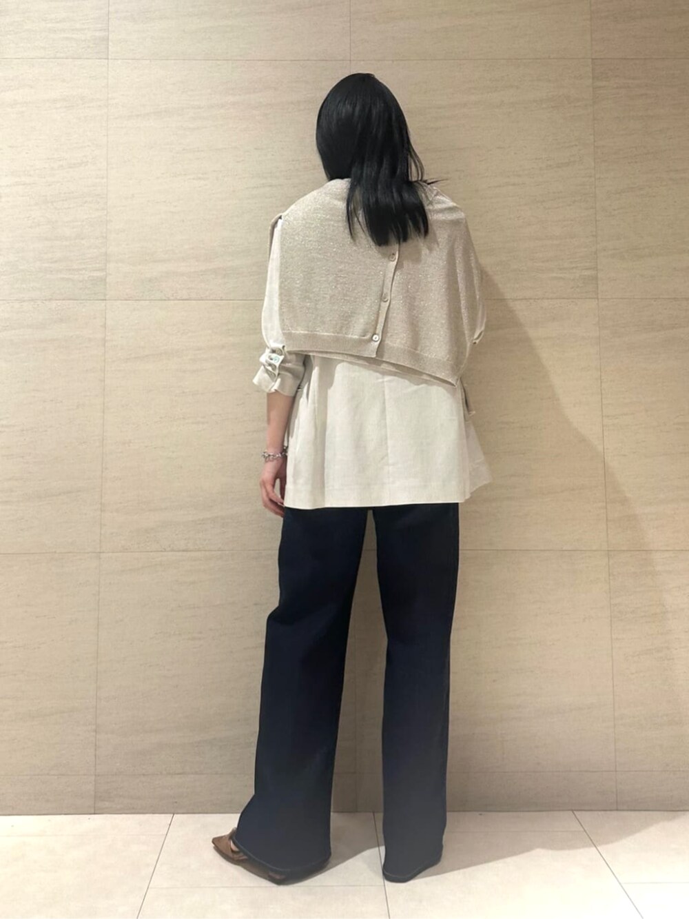 ブルー系のデニムパンツ、ベージュ系のテーラードジャケット、ベージュ系のタンクトップを着用したレディースの夏コーディネートの5枚目の写真