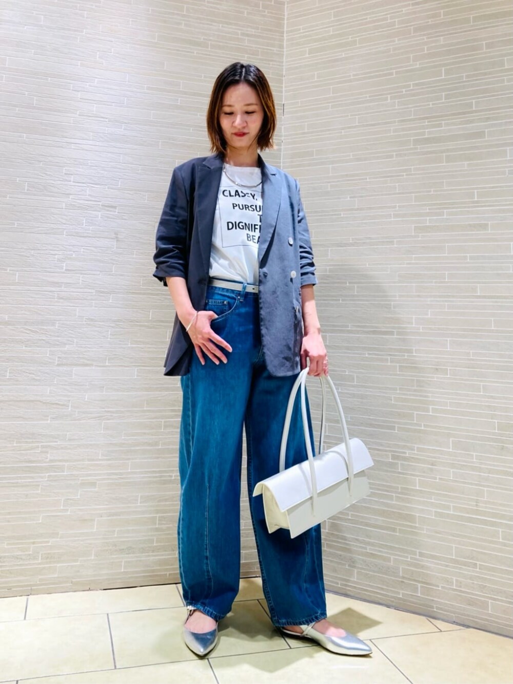 ホワイト系のTシャツ/カットソー、グレー系のテーラードジャケット、ブルー系のデニムパンツを着用したレディースの春コーディネートの2枚目の写真