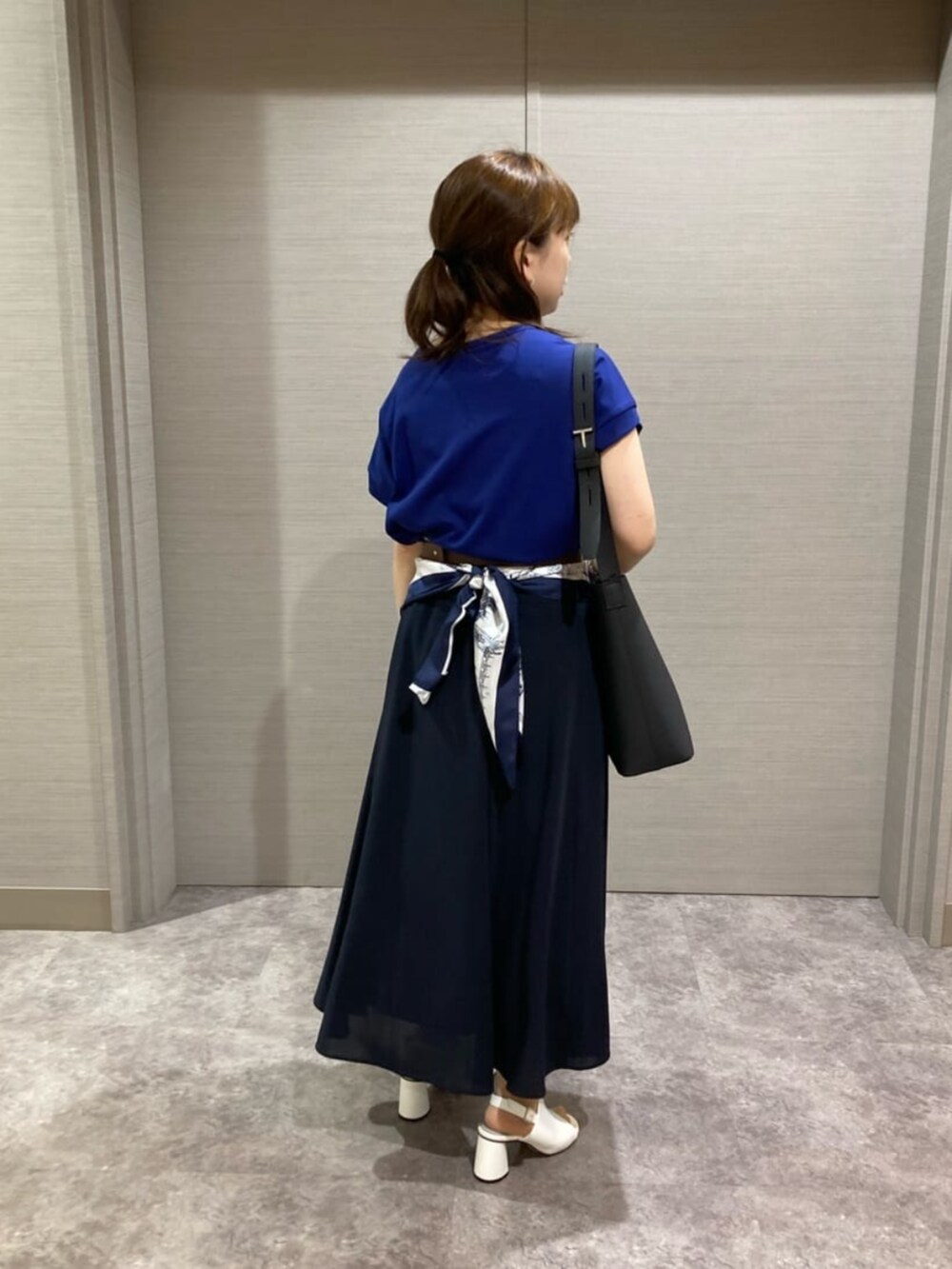 ホワイト系のショルダーバッグ、ブルー系のスカート、ホワイト系のサンダルを着用したレディースの夏コーディネートの3枚目の写真