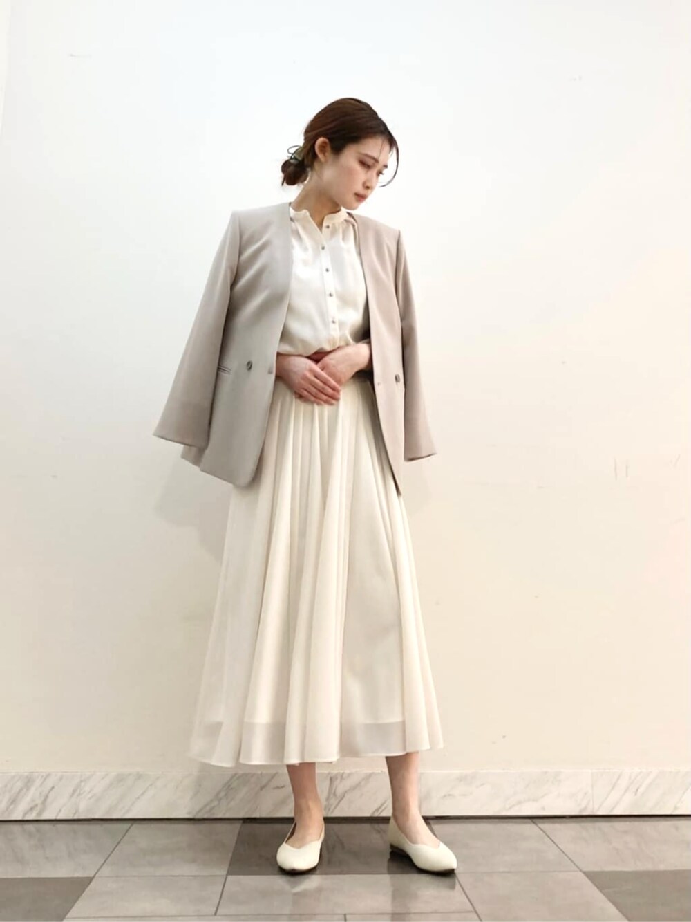 ホワイト系のスカート、グレー系のスーツジャケットを着用したレディースの春コーディネートの3枚目の写真