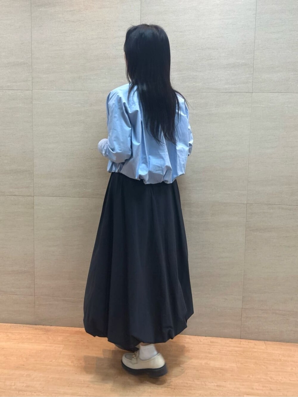 ブラック系のスカート、ブルー系のシャツ/ブラウス、シルバー系のタンクトップを着用したレディースの春コーディネートの5枚目の写真