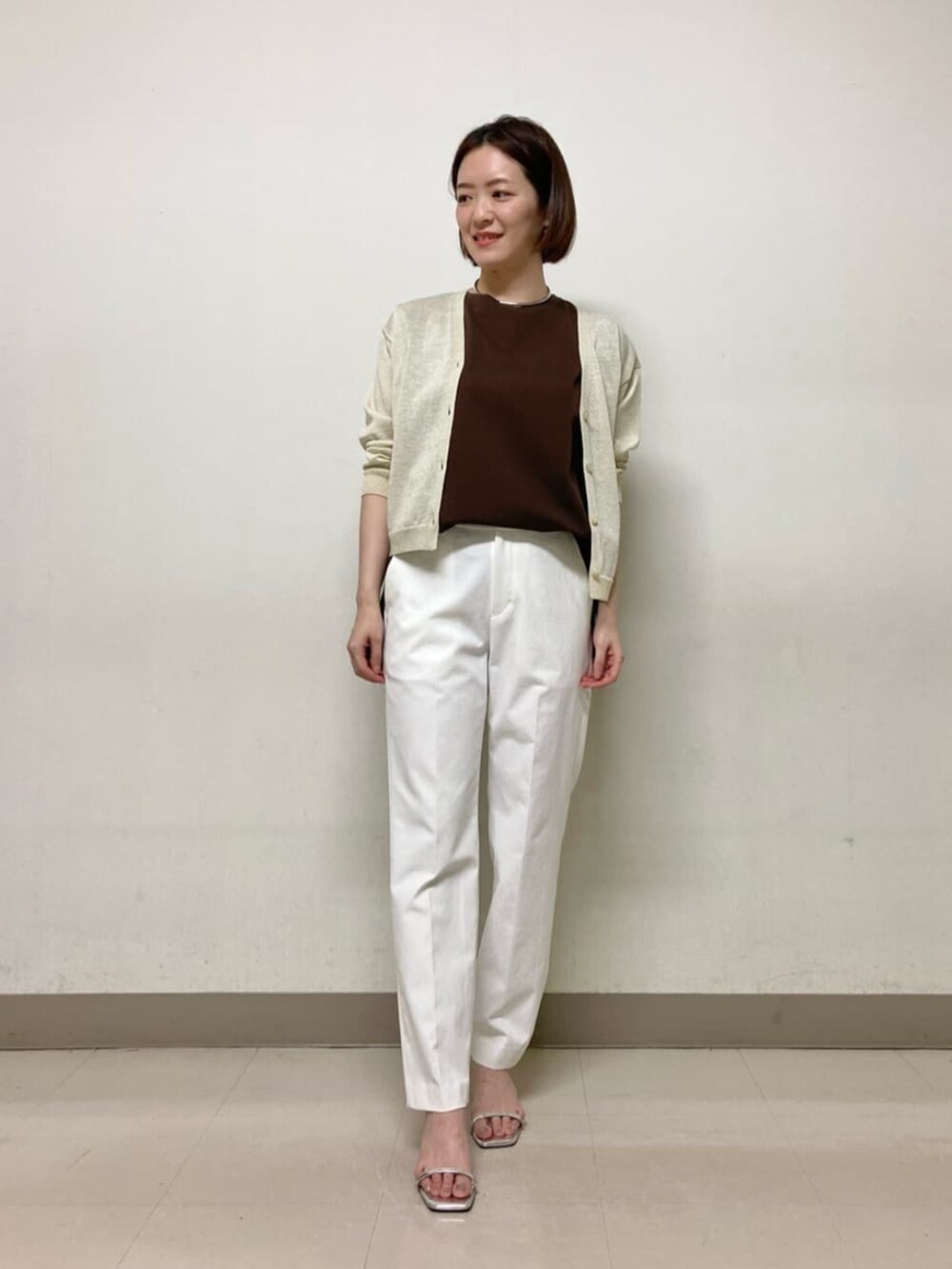 イエロー系のカーディガン/ボレロ、ブラウン系のTシャツ/カットソー、ホワイト系のパンツを着用したレディースの春コーディネートの4枚目の写真