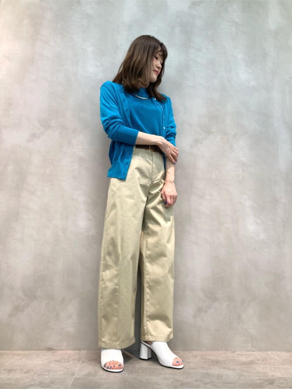 ベージュ系のチノパンツ、ホワイト系のサンダル、グリーン系のニット/セーターを着用したレディースの夏コーディネートの4枚目の写真