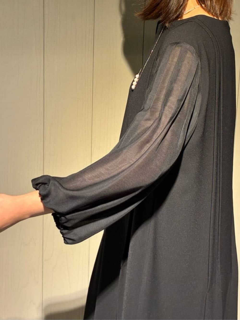 ベージュ系のノーカラージャケット、ブラック系のワンピース、ブラック系のパンプスを着用したレディースの冬コーディネートの7枚目の写真