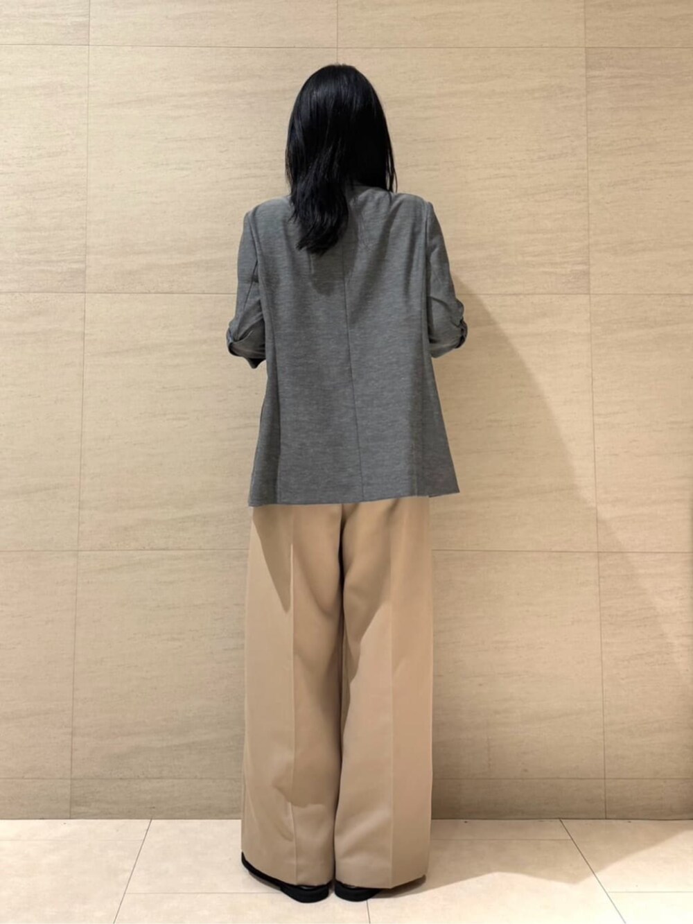 グレー系のテーラードジャケット、ベージュ系のパンツ、ブラック系のベルトを着用したレディースの夏コーディネートの4枚目の写真