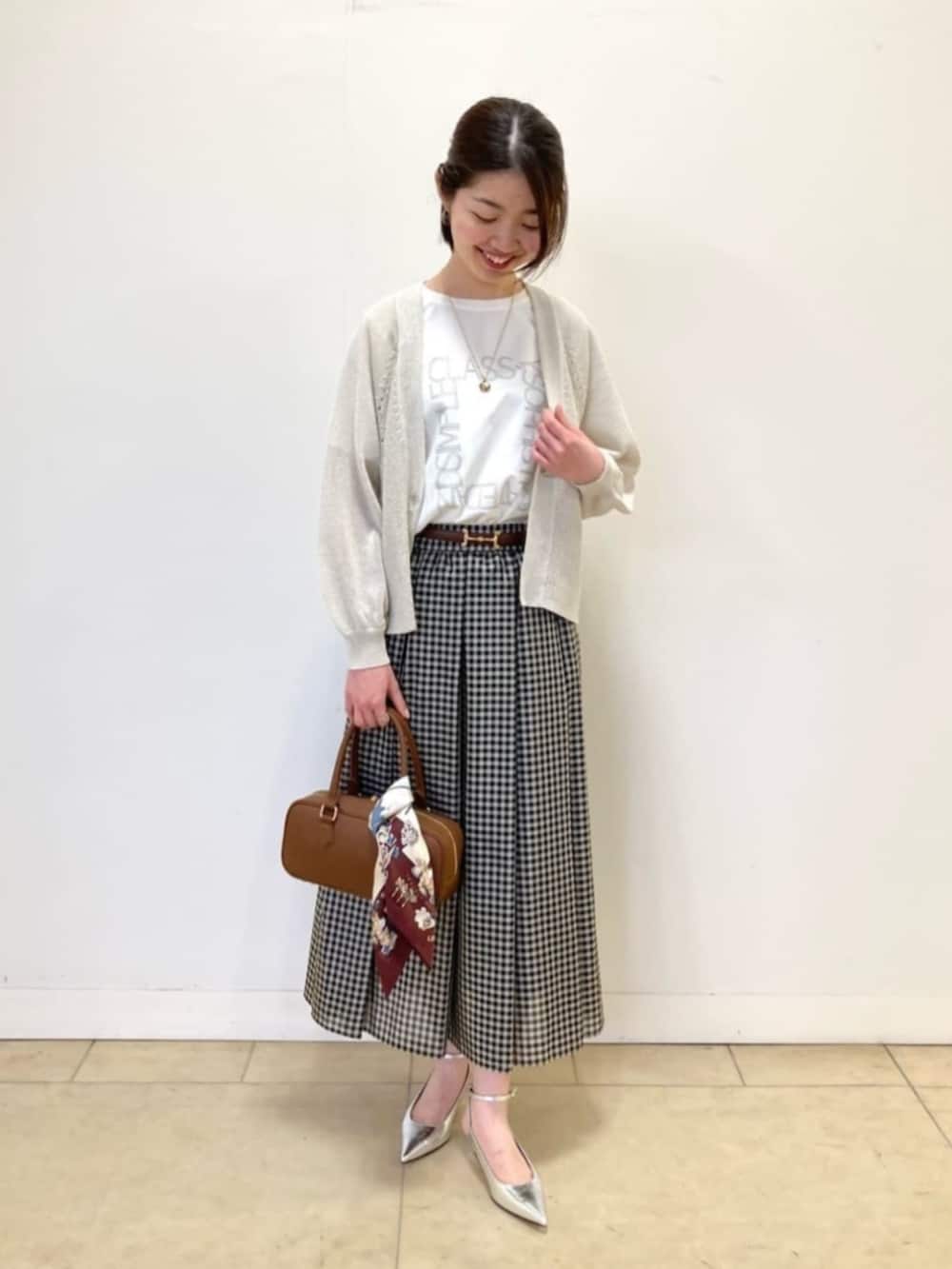 ベージュ系のカーディガン/ボレロ、ホワイト系のTシャツ/カットソー、ブラック系のスカートを着用したレディースの春コーディネートの3枚目の写真