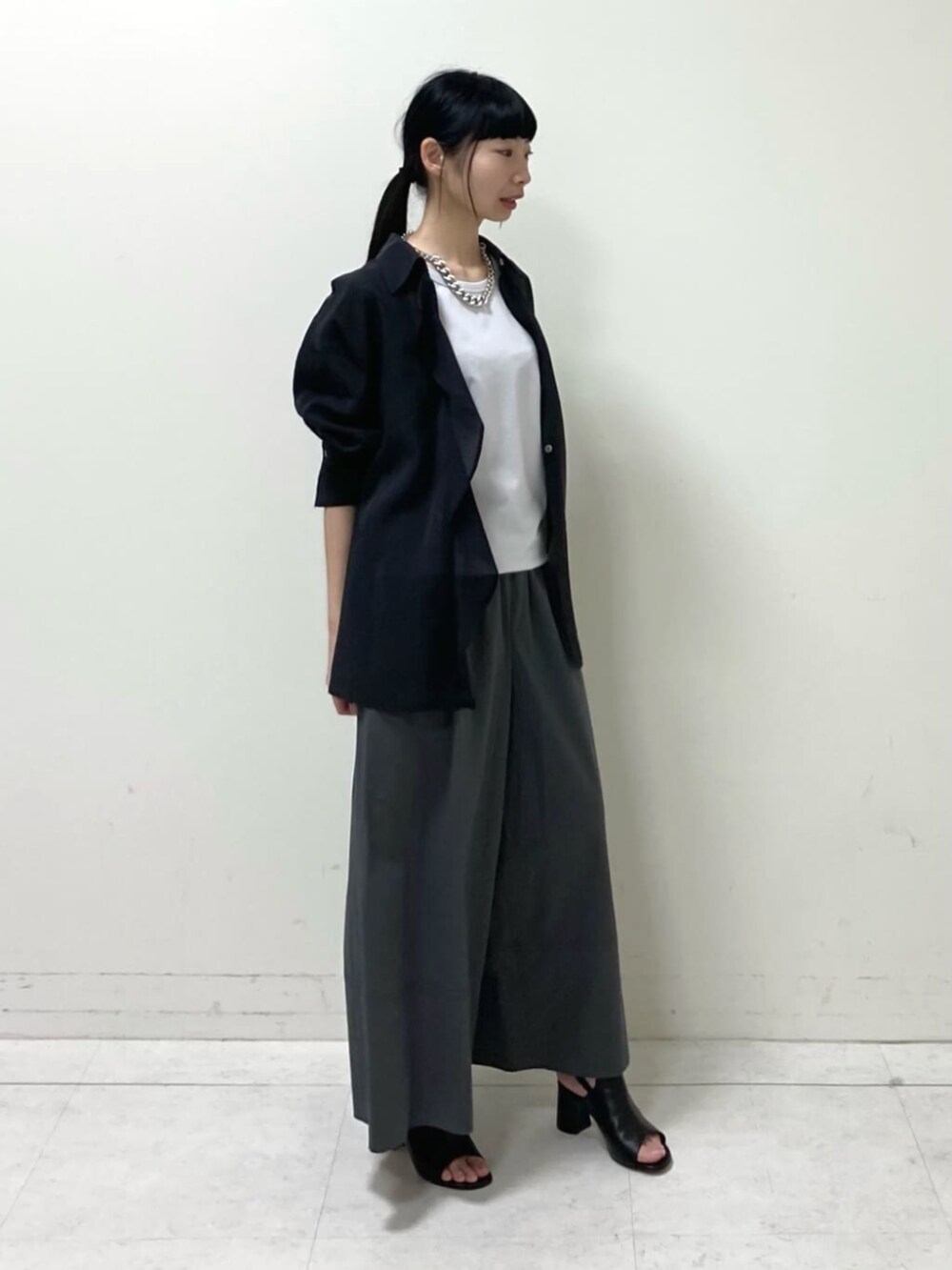 ブラック系のシャツ/ブラウス、ブラック系のサンダル、ホワイト系のタンクトップを着用したレディースの春コーディネートの2枚目の写真