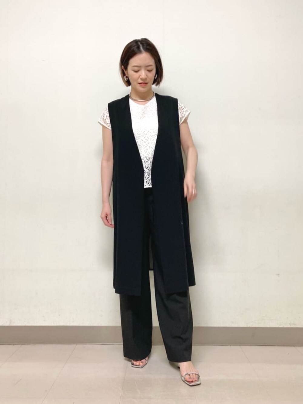 ブラック系のベスト、ホワイト系のシャツ/ブラウス、ブラック系のその他パンツを着用したレディースの春コーディネートの2枚目の写真