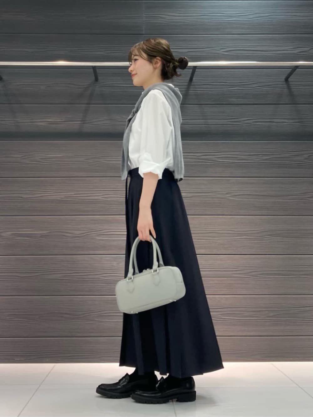 ブラック系のその他シューズ、ホワイト系のシャツ/ブラウス、ブルー系のスカートを着用したレディースの春コーディネートの3枚目の写真