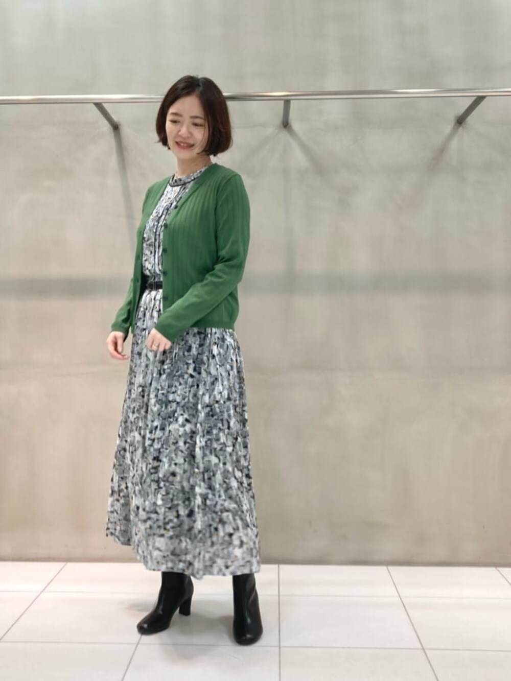 ブラック系のワンピース、グリーン系のカーディガン/ボレロを着用したレディースの春コーディネートの2枚目の写真