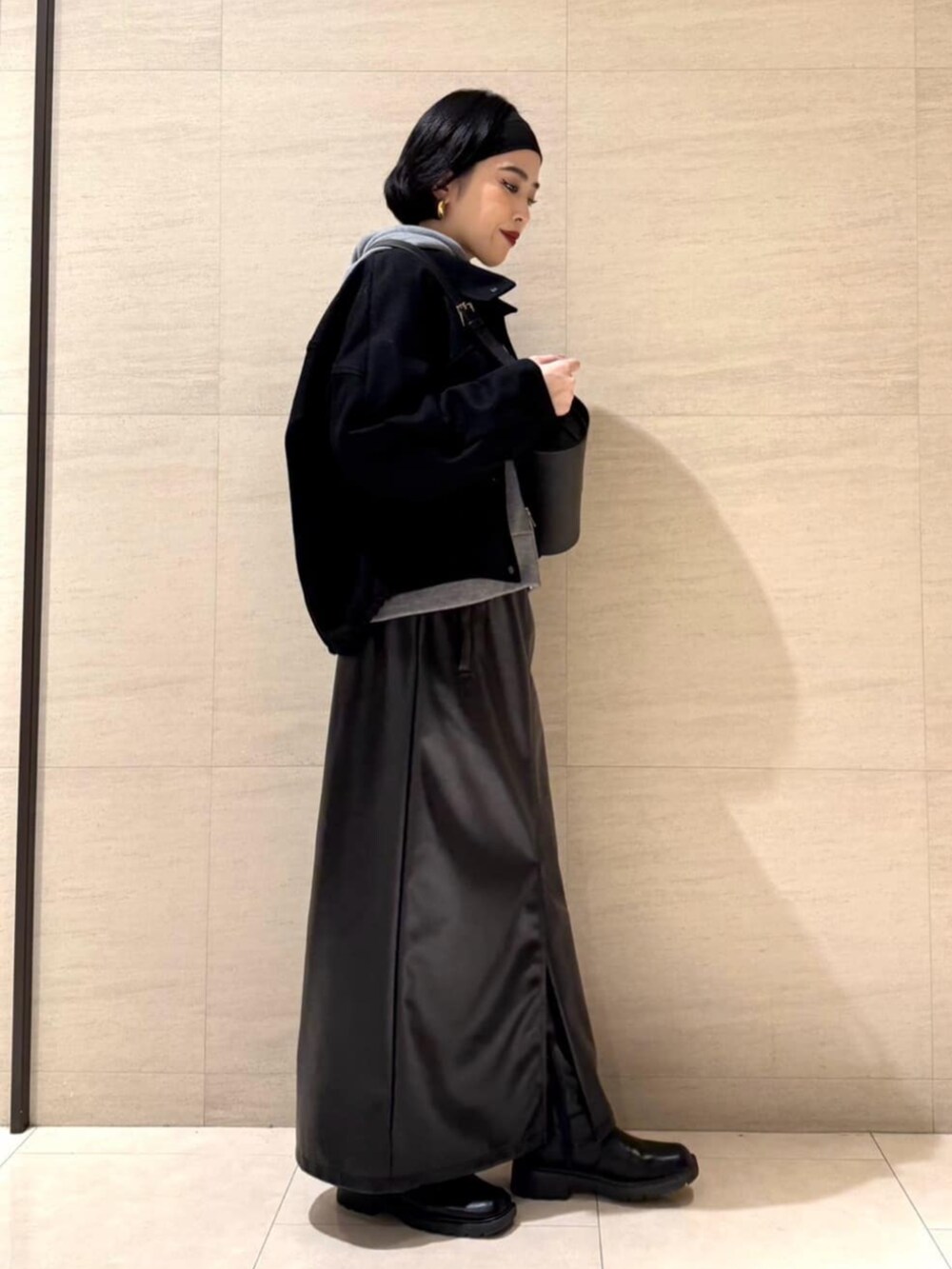 ブラック系のスカート、ブラック系のショルダーバッグ、ブラック系のブルゾンを着用したレディースの冬コーディネートの4枚目の写真