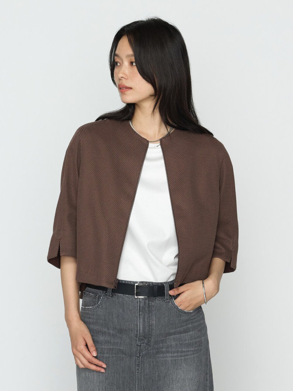 ブラウン系のブルゾン、グレー系のスカートを着用したレディースの春コーディネートの3枚目の写真