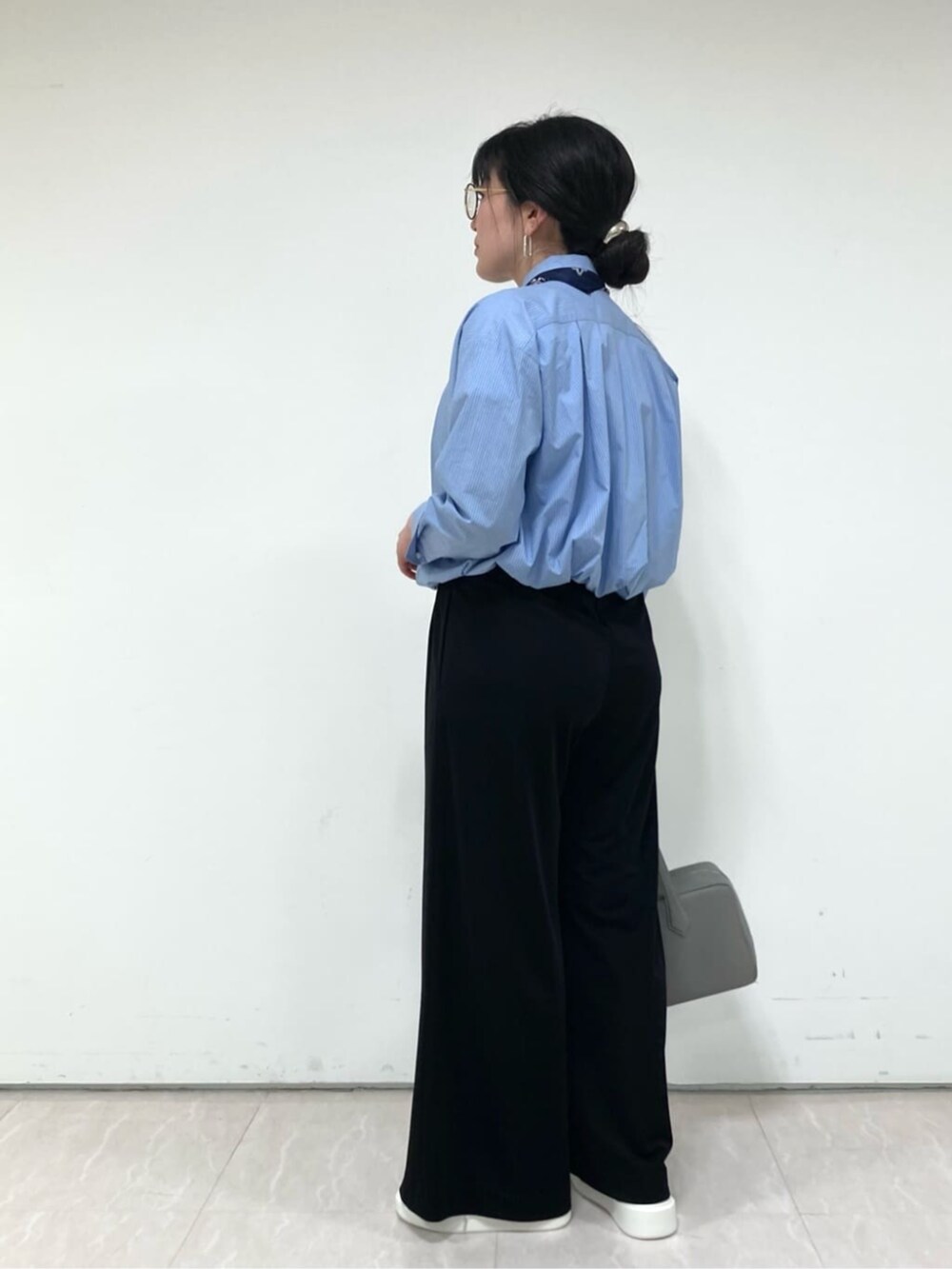 ブルー系のシャツ/ブラウス、ホワイト系のTシャツ/カットソー、ブラック系のパンツを着用したレディースの春コーディネートの3枚目の写真