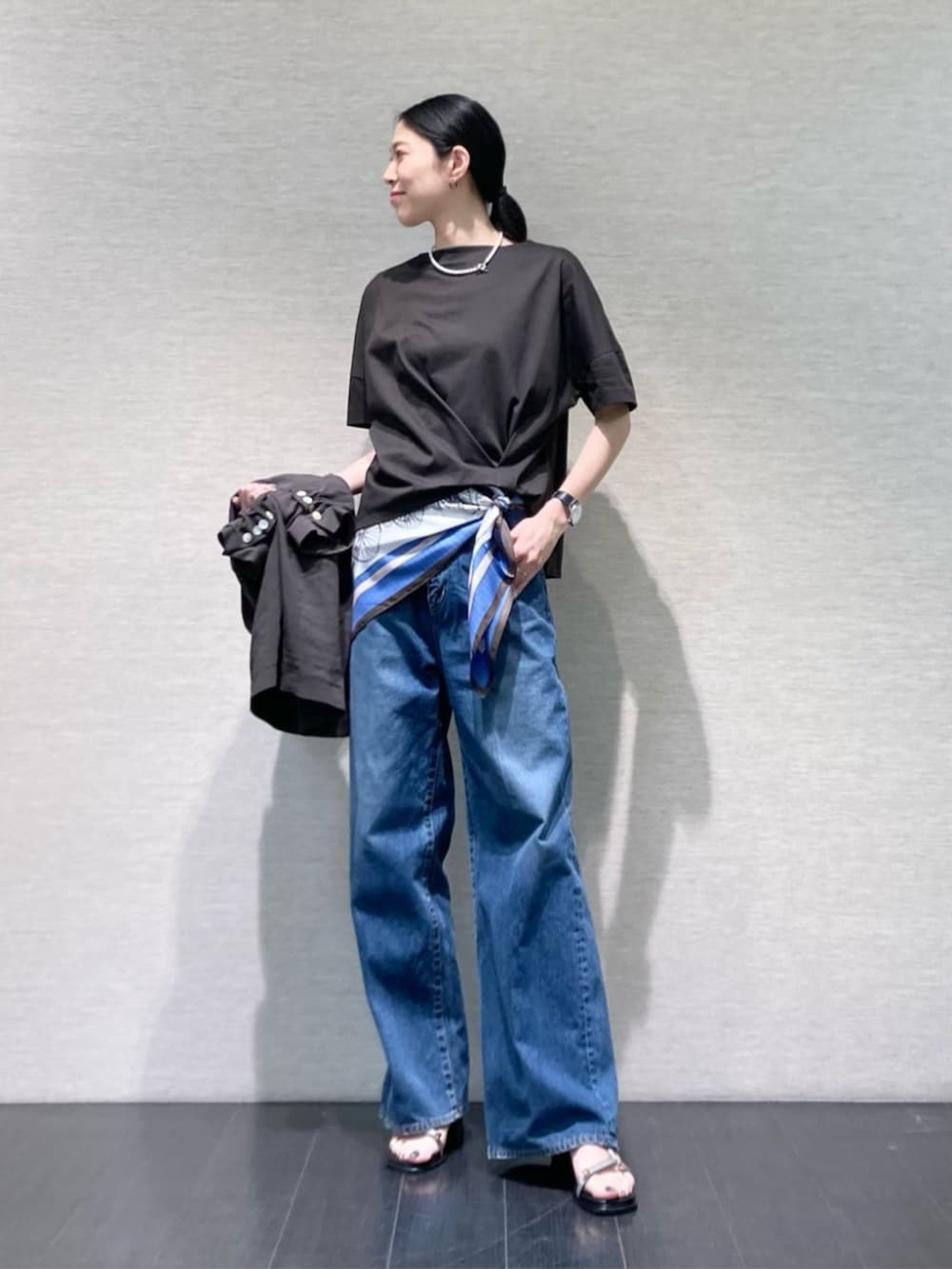 ブルー系のデニムパンツ、グレー系のテーラードジャケット、グレー系のサンダルを着用したレディースの夏コーディネートの4枚目の写真