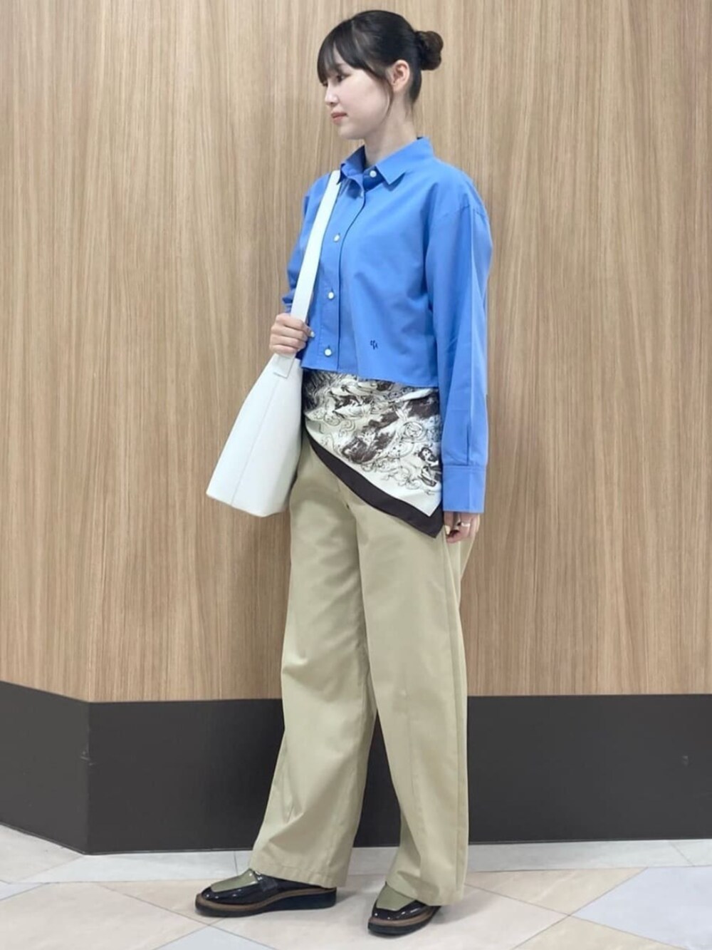 ブルー系のシャツ/ブラウス、グレー系のチノパンツ、ブラウン系のストール/ショールを着用したレディースの夏コーディネートの3枚目の写真