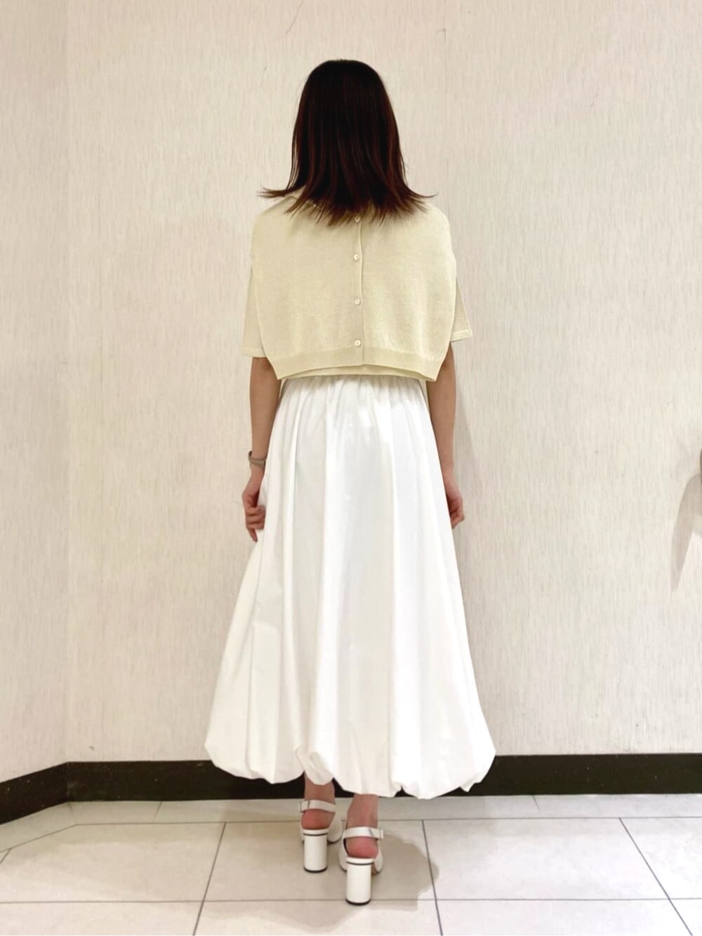 ホワイト系のスカート、イエロー系のカーディガン/ボレロ、イエロー系のニット/セーターを着用したレディースの春コーディネートの5枚目の写真
