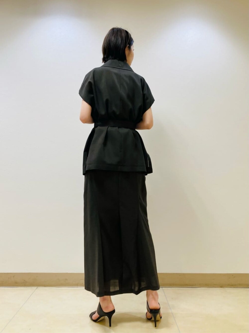 ブラウン系のベスト、ブラウン系のスカート、ゴールド系のネックレスを着用したレディースの夏コーディネートの4枚目の写真